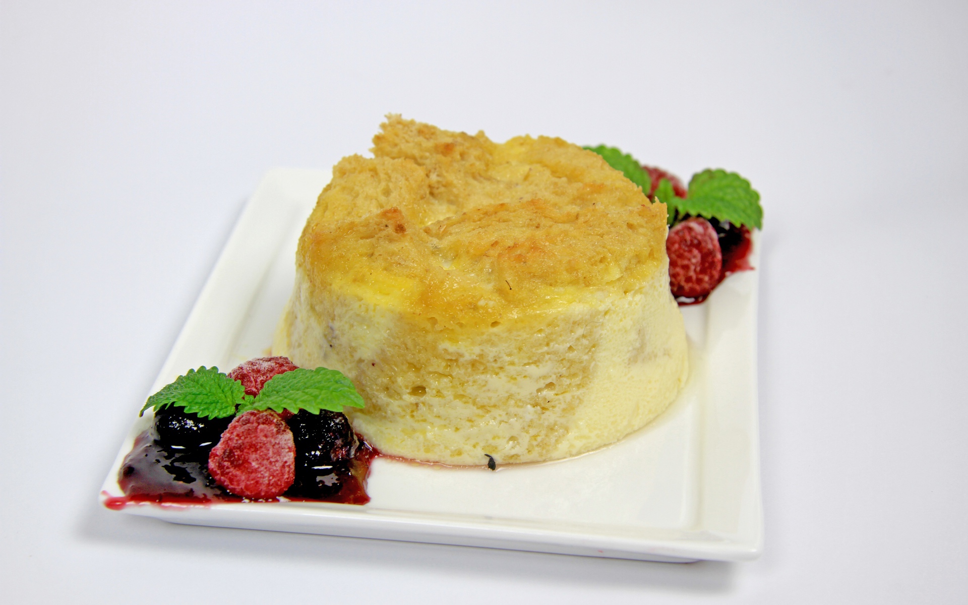 Пирожное на большой белой тарелке с ягодами