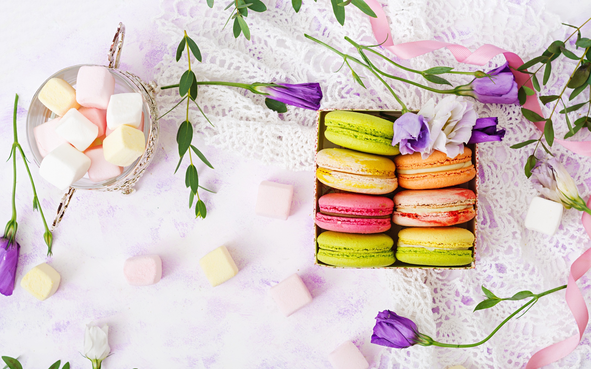 Десерт макарон на столе с кружевной салфеткой и маршмеллоу