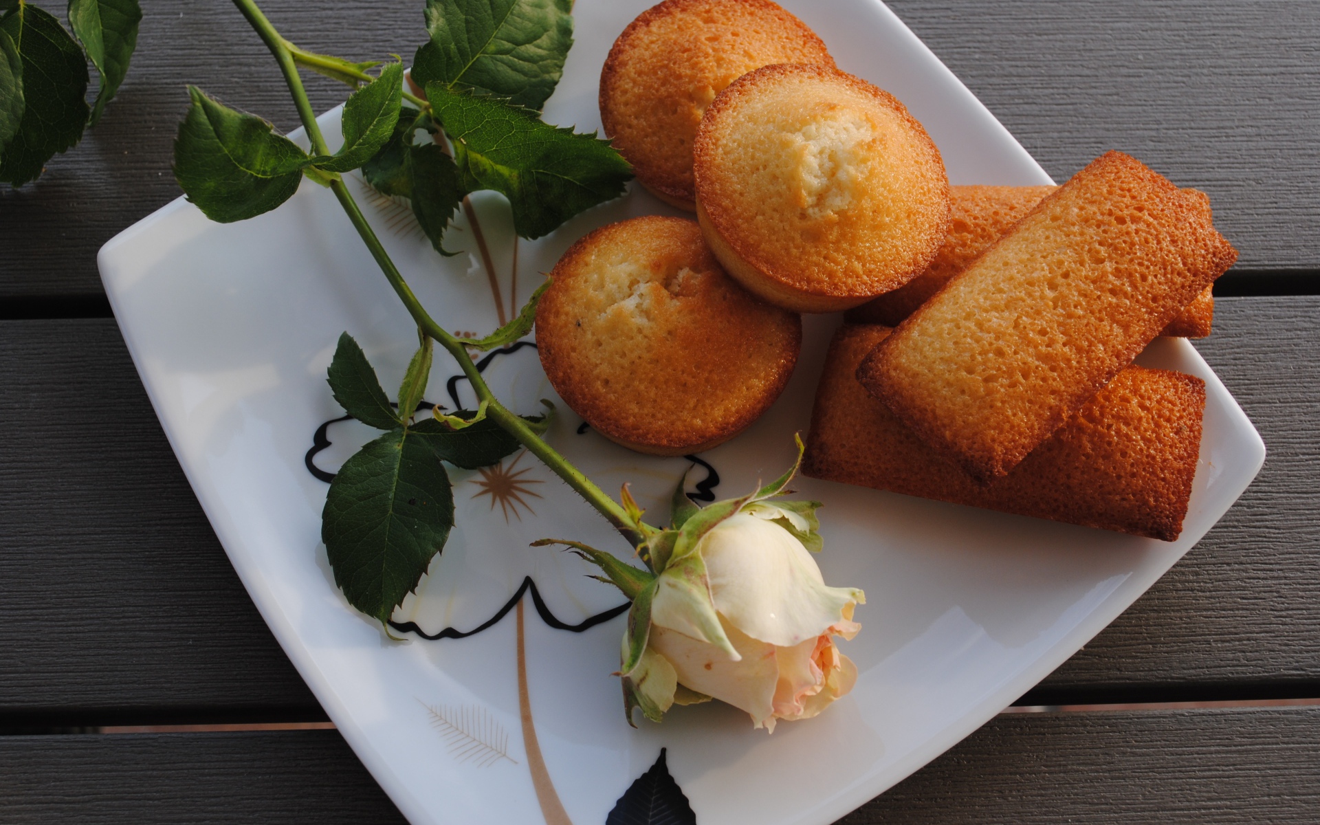 Свежие кексы на белой тарелке с розой