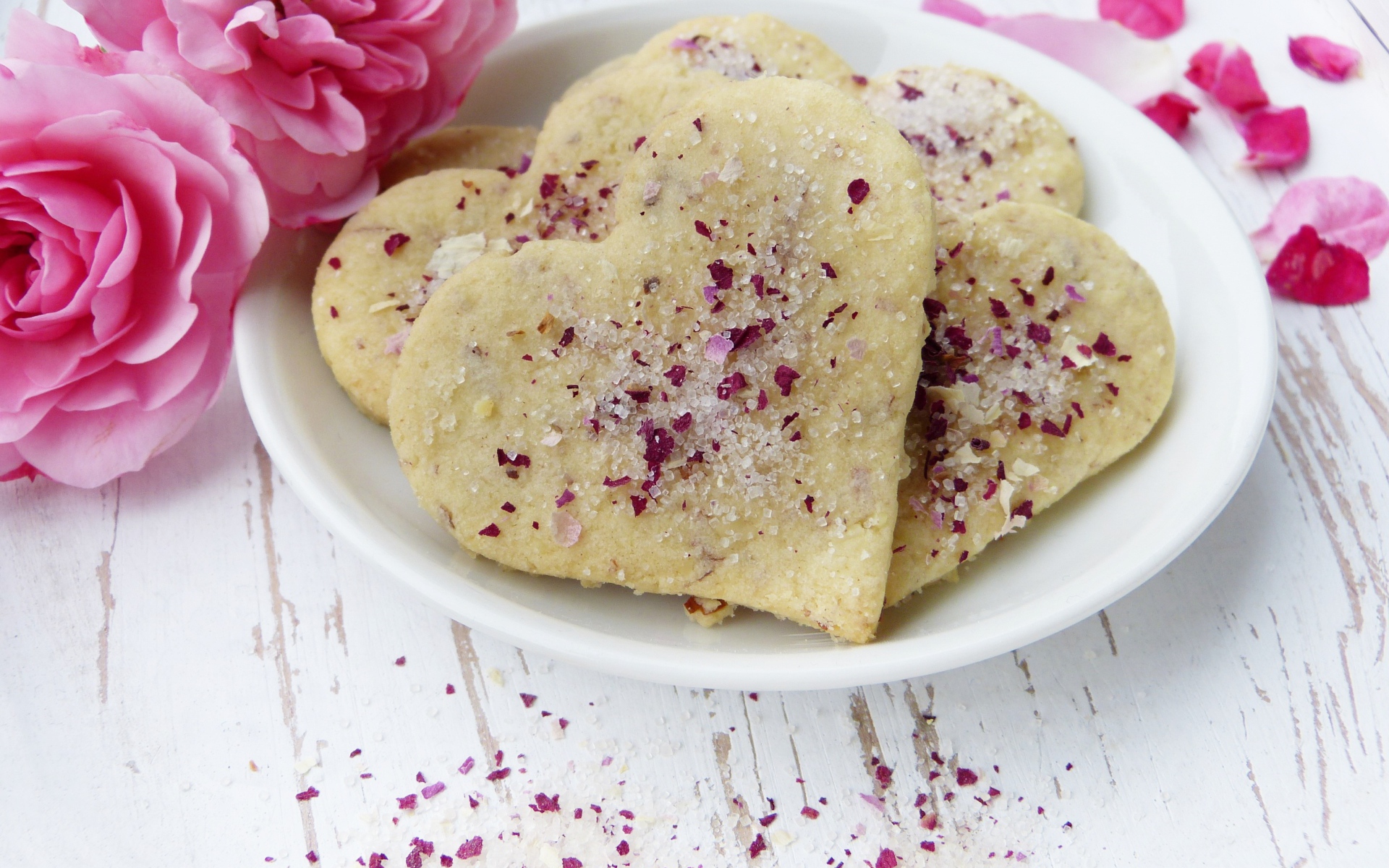 Песочное печенье в форме сердца в белой тарелке с цветами