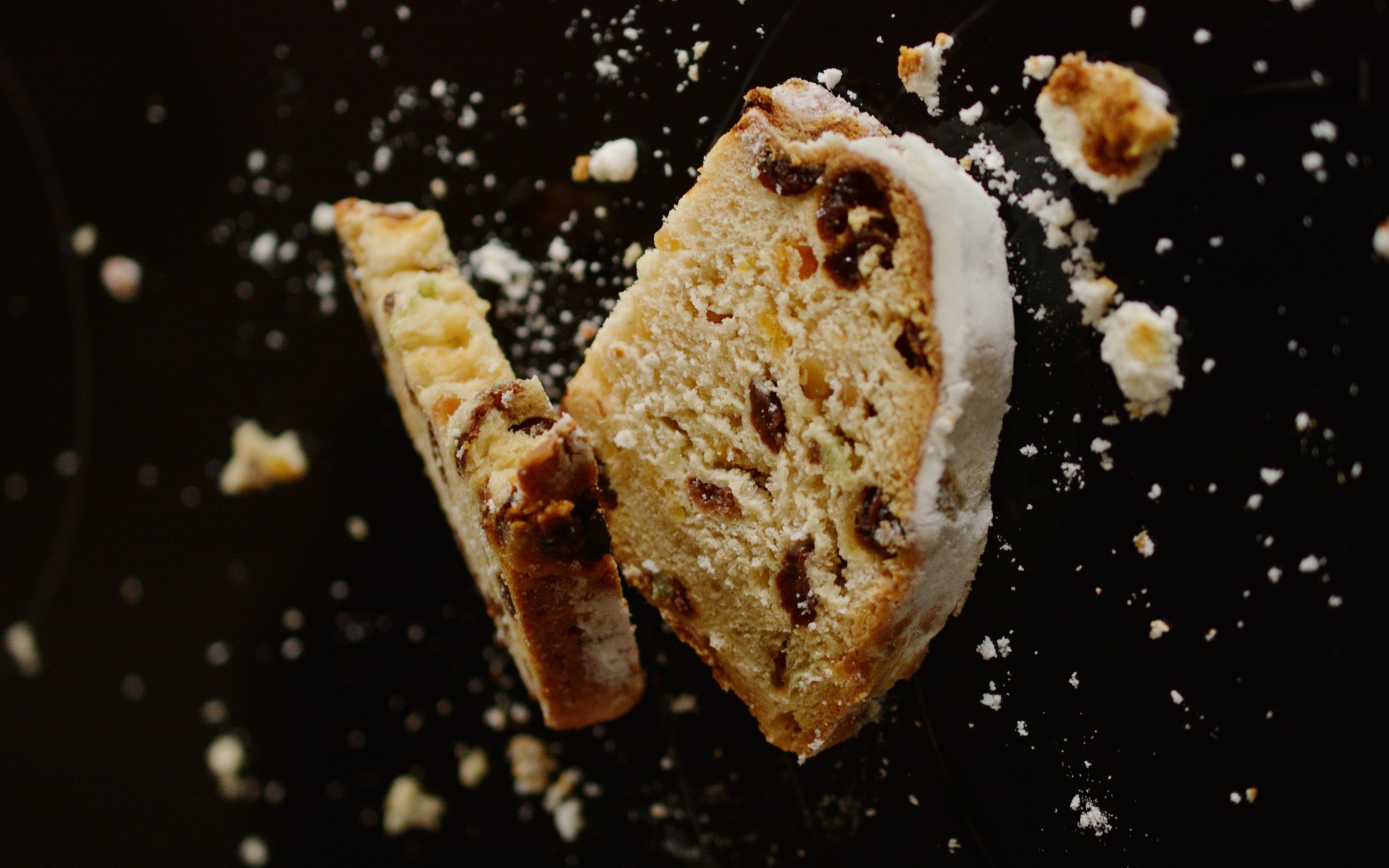 Два куска кекса с изюмом на черном фоне 