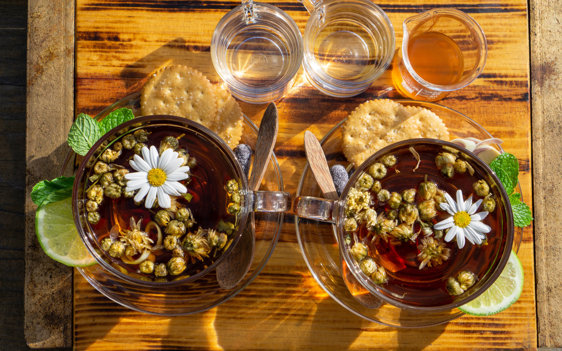 Две чашки чая с ромашкой на столе с медом