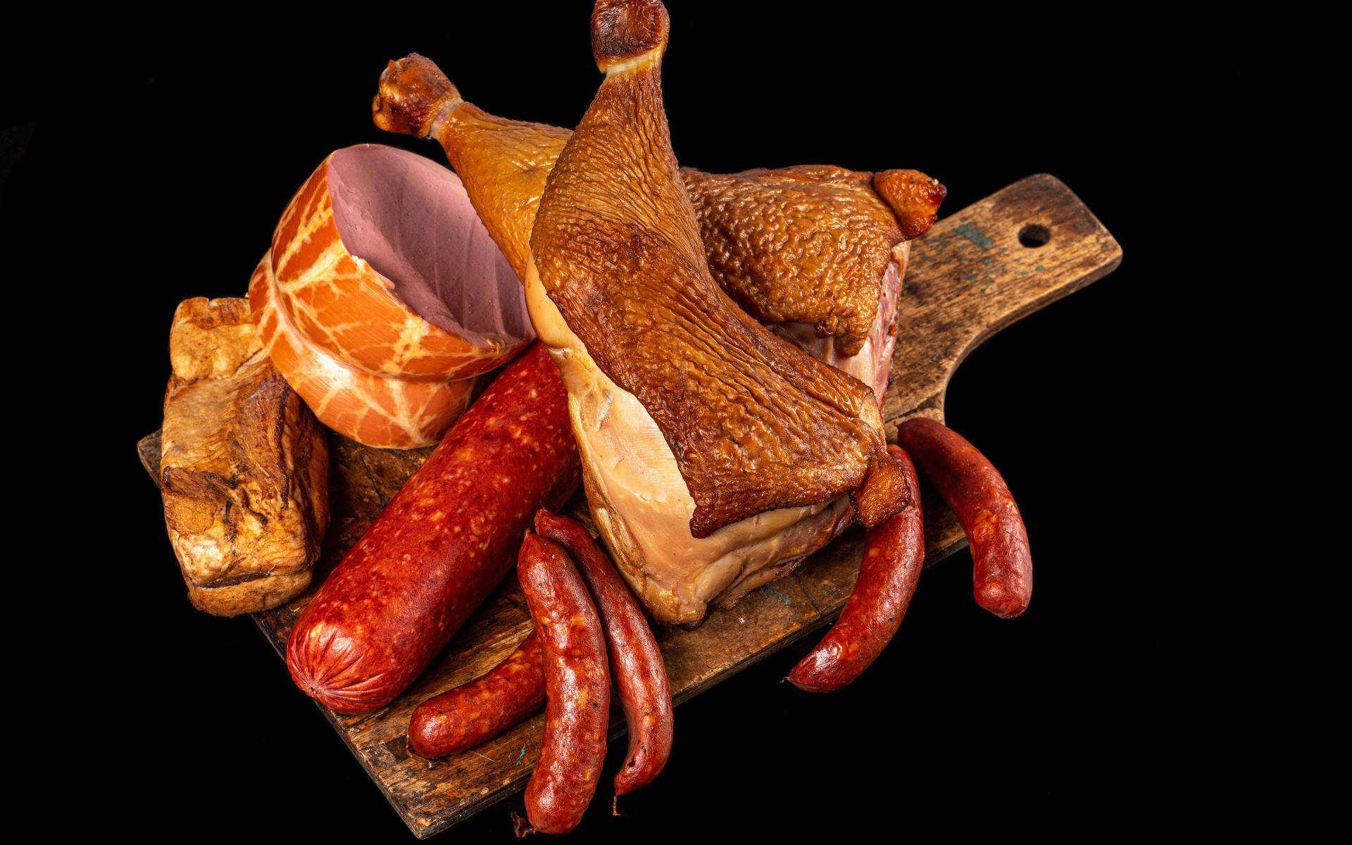 Appetizing smoked meats and sausage on a black background