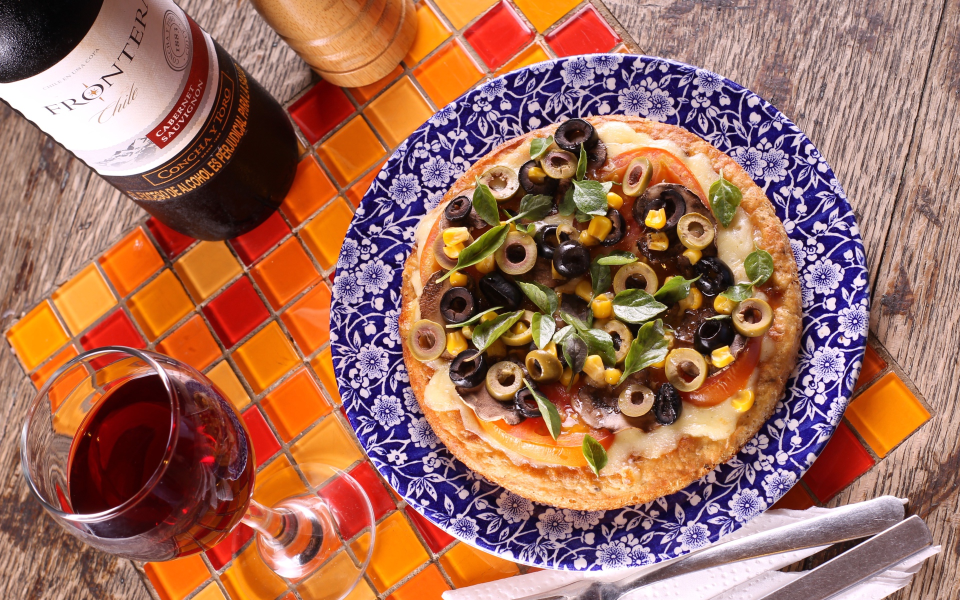 Итальянская пицца с оливками на столе с вином