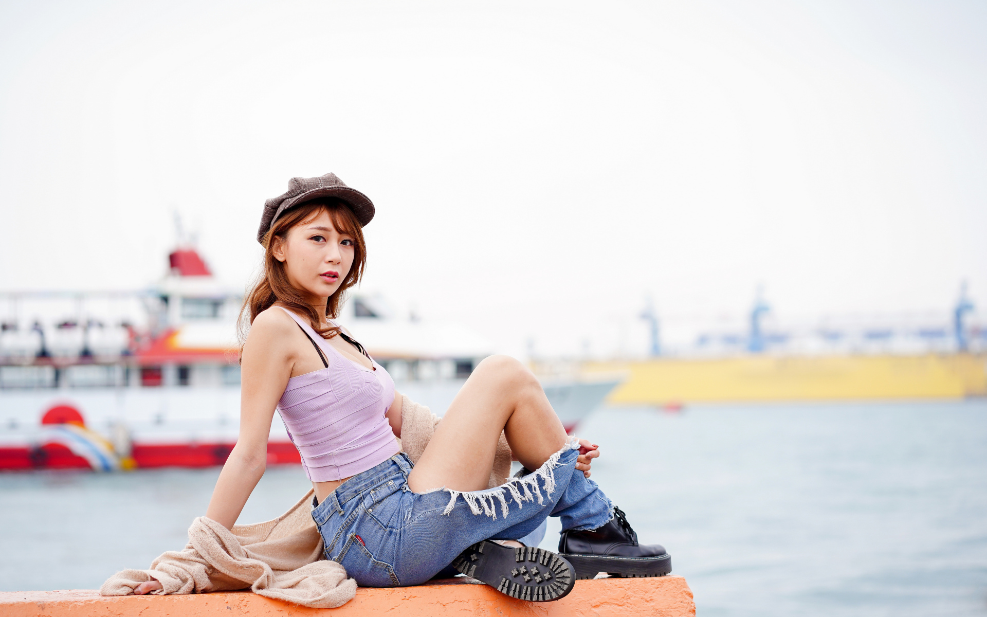 Красивая девушка азиатка в джинсах у моря