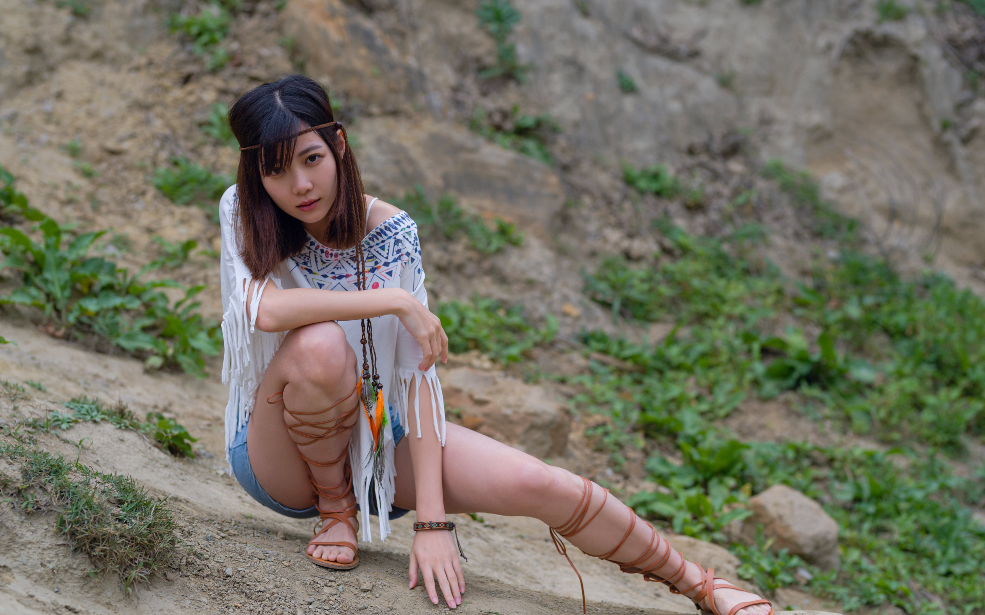 Красивая девушка азиатка сидит на земле  в туфлях