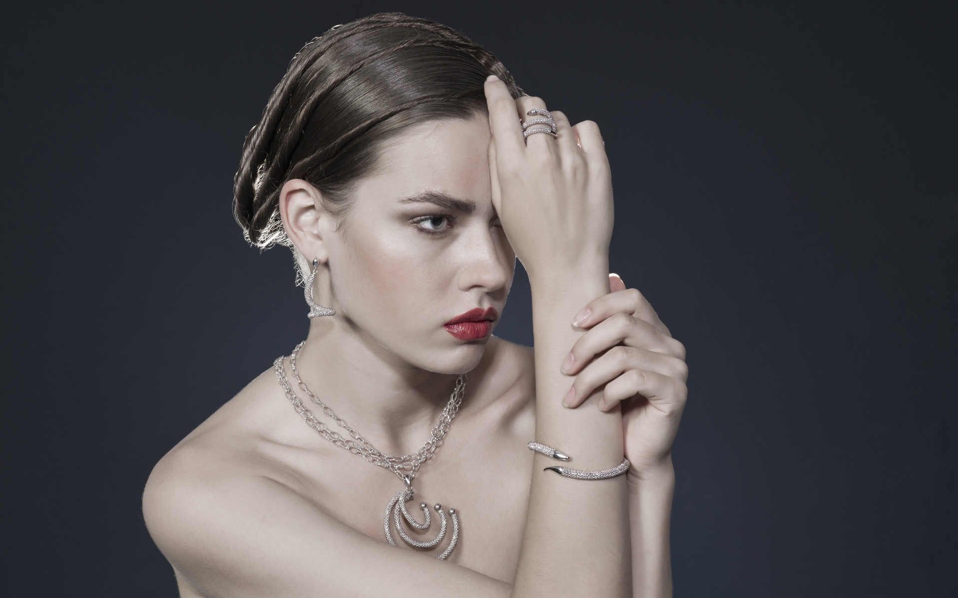 Красивая девушка с украшениями на теле на сером фоне