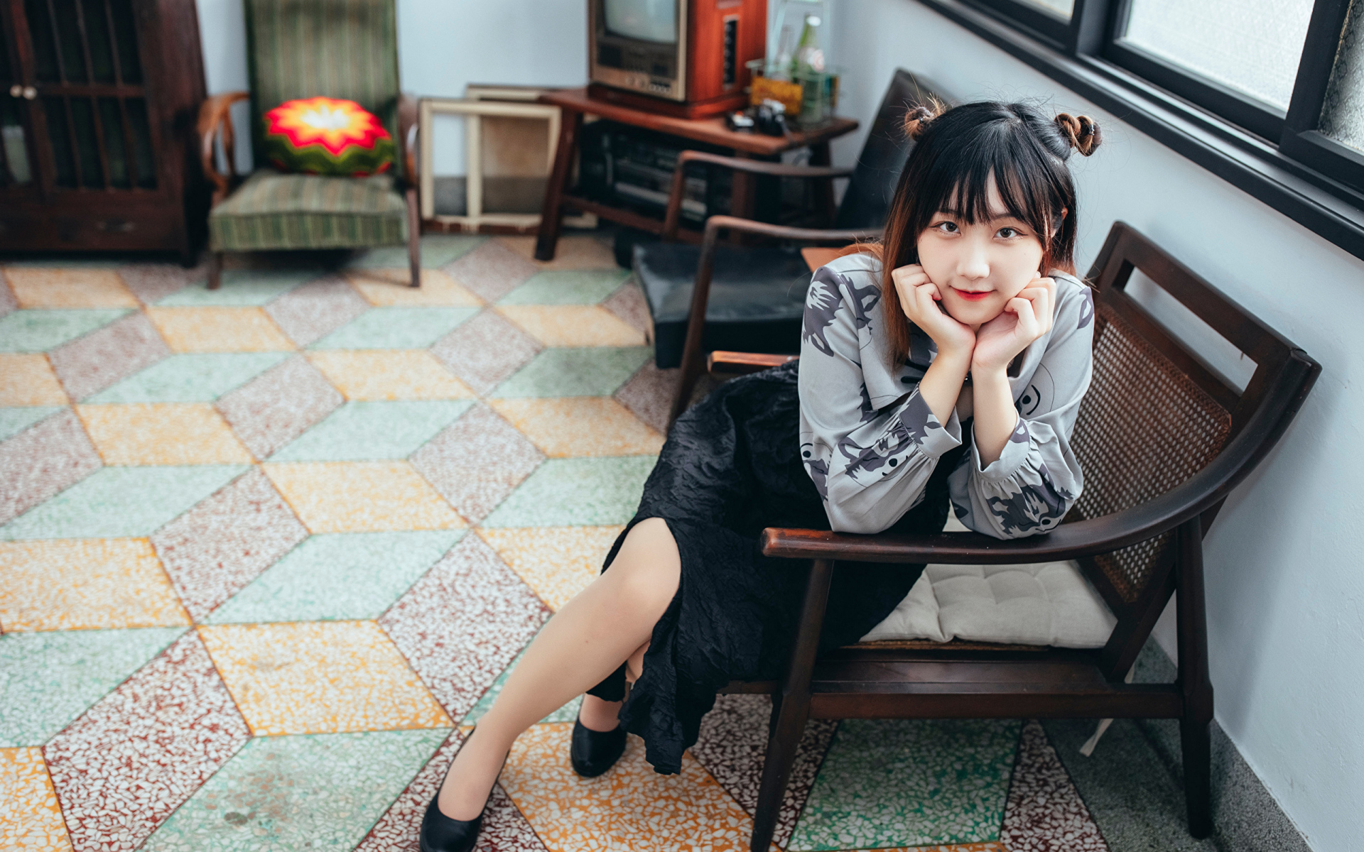 Красивая молодая азиатка сидит в кресле