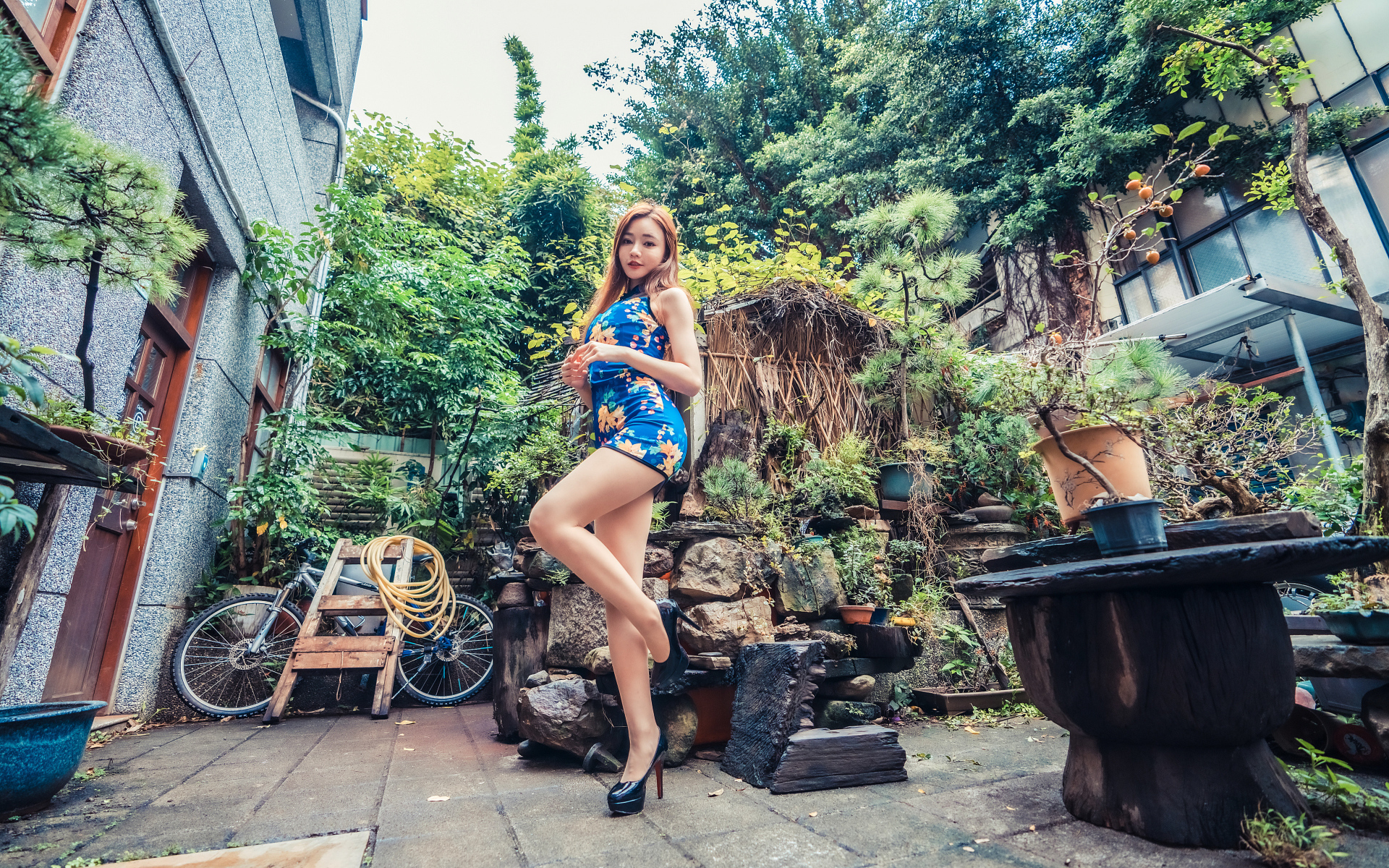 Милая азиатка в коротком платье у дома 