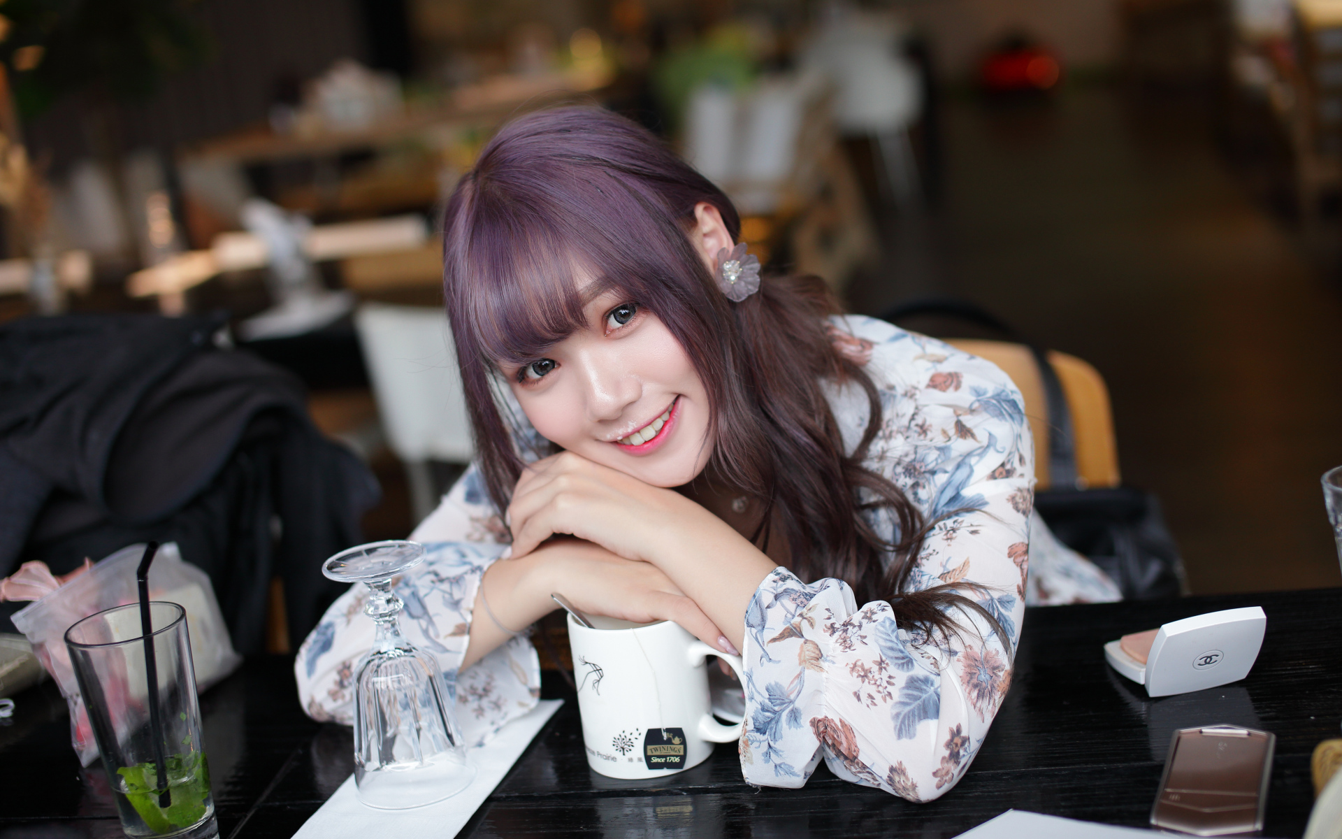 Милая девушка азиатка сидит за столиком