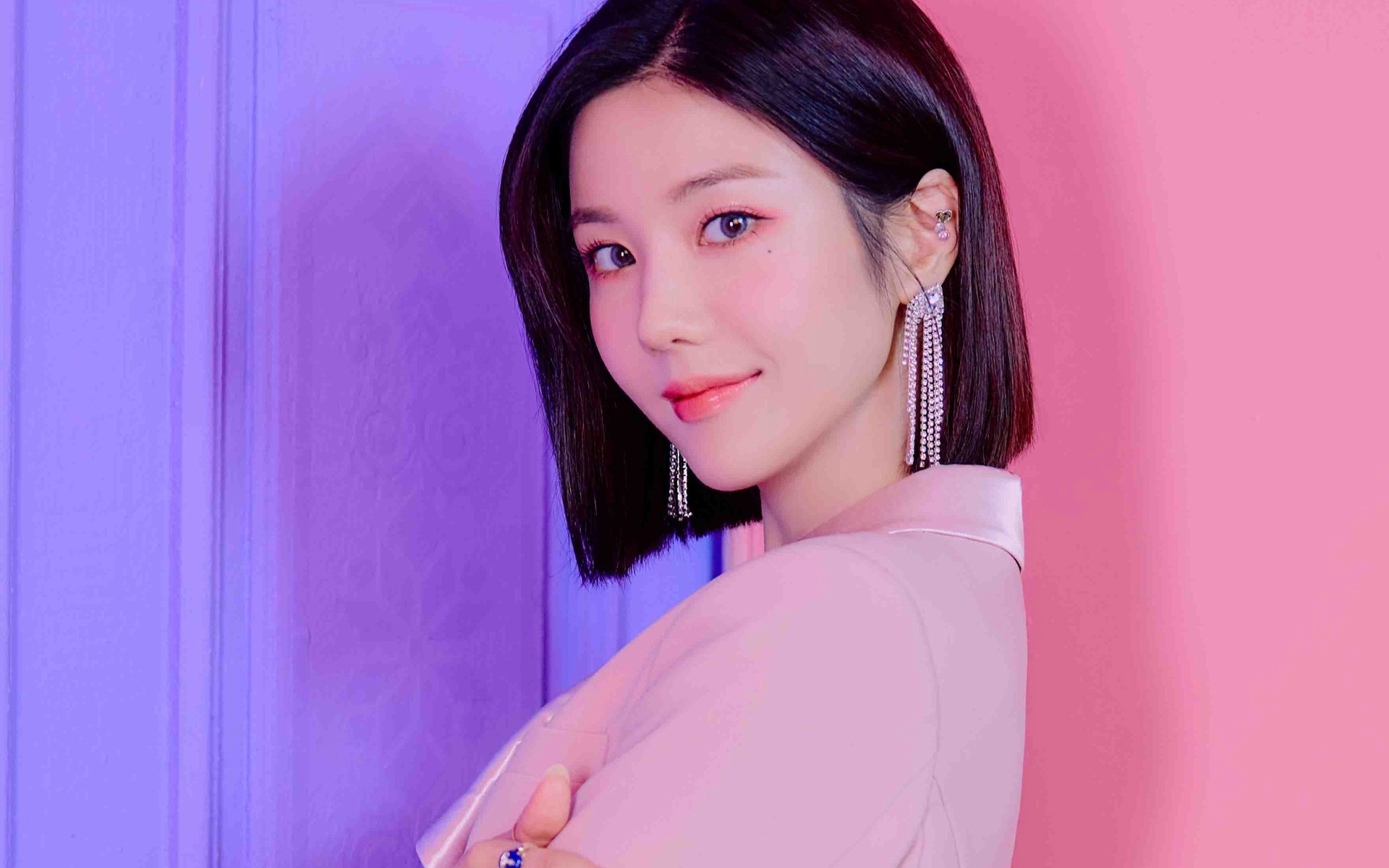 Милая девушка азиатка с короткой стрижкой на розовом фоне 