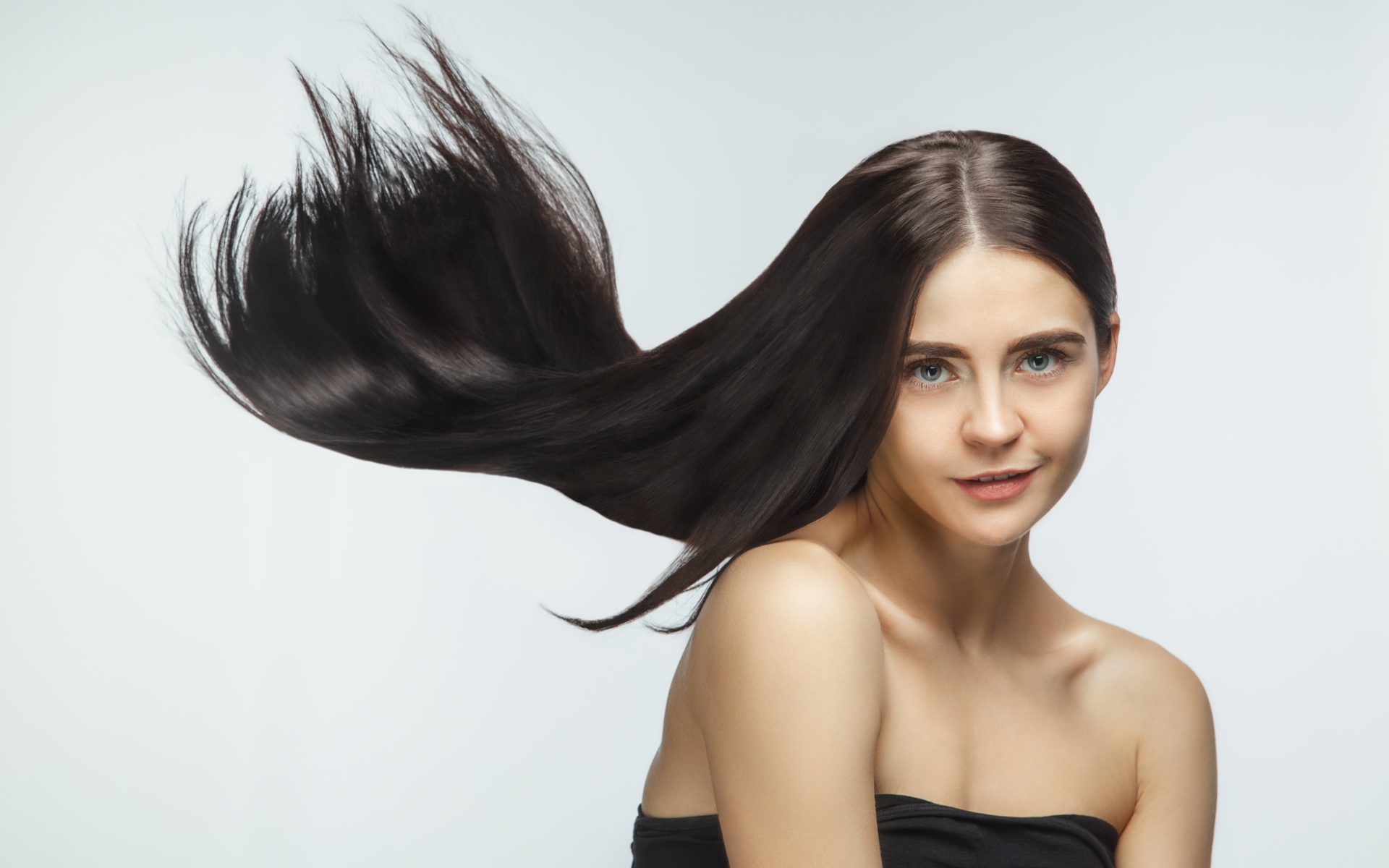 Длинные шелковистые волосы молодой брюнетки 