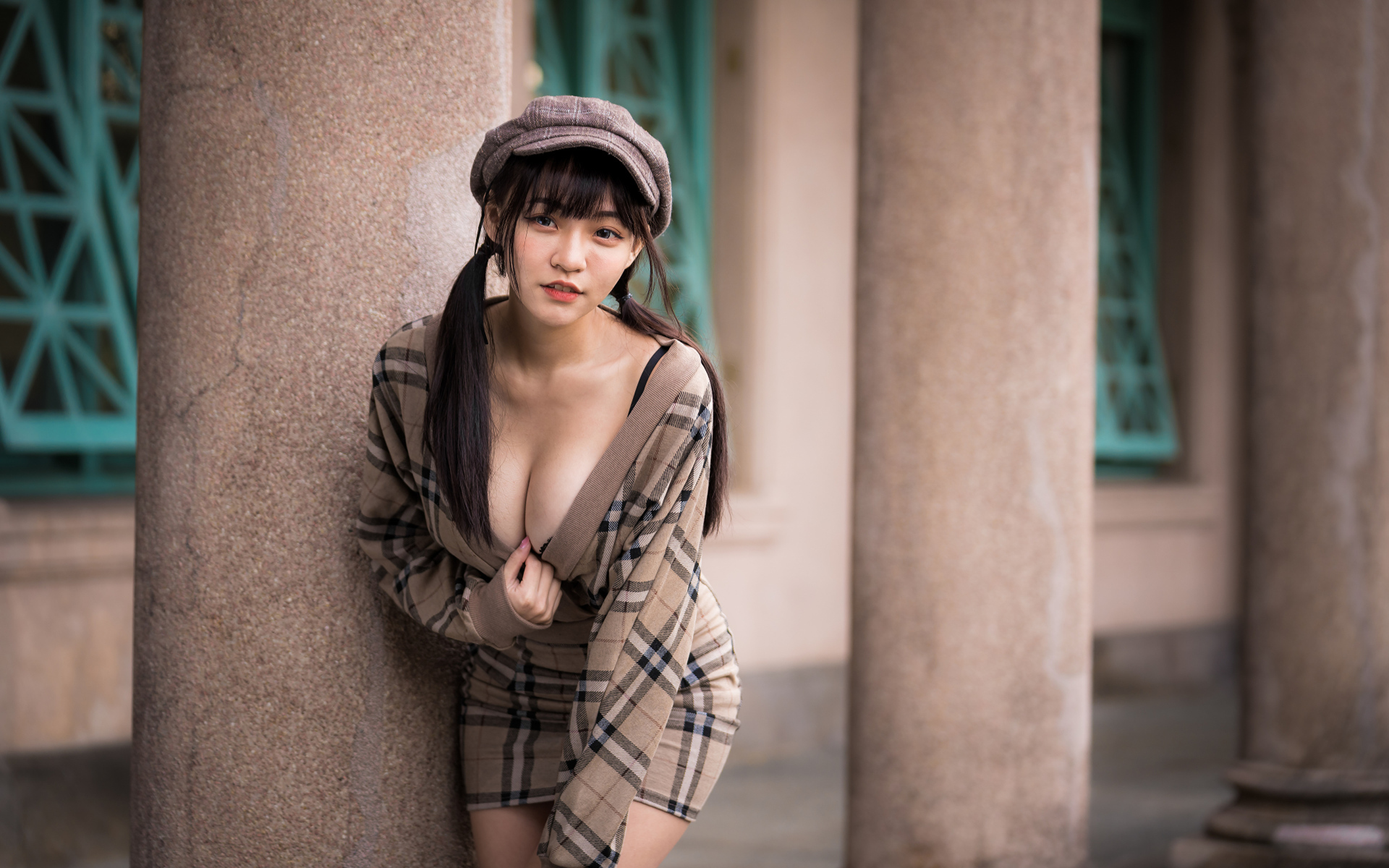 Сексуальная девушка азиатка стоит у колонны 