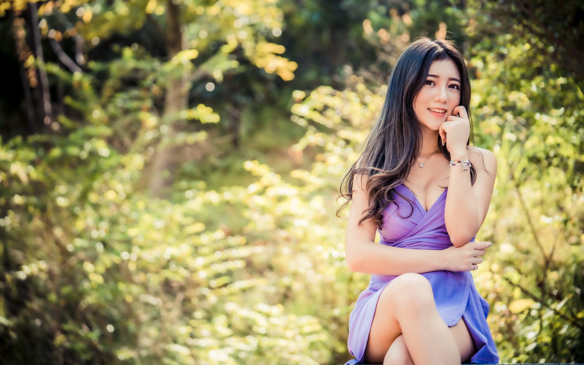 Улыбающаяся девушка азиатка в сиреневом платье