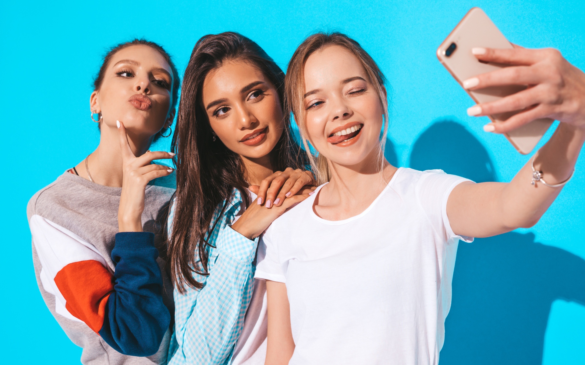 Three female friends take a selfie on a blue background Desktop wallpapers  1920x1200