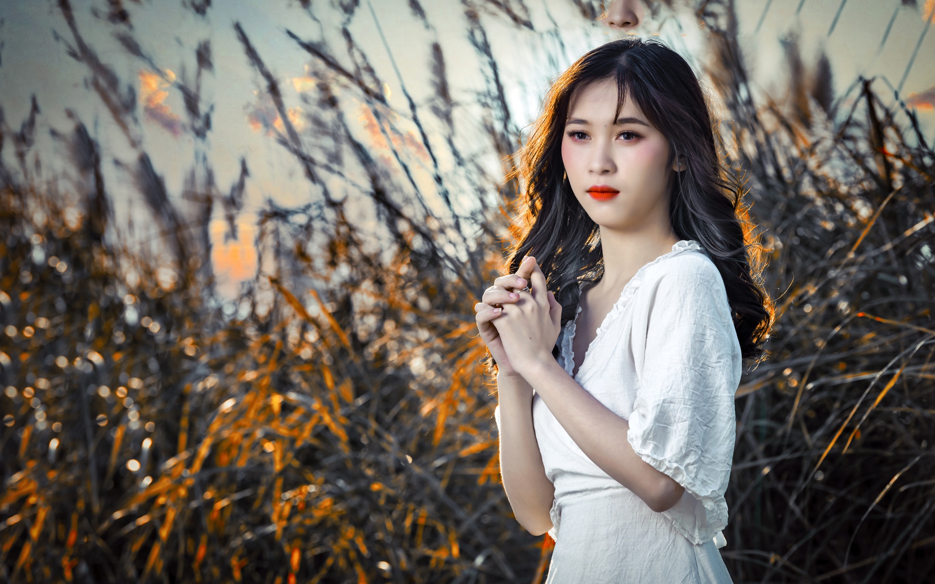 Молодая девушка азиатка в белом платье на закате