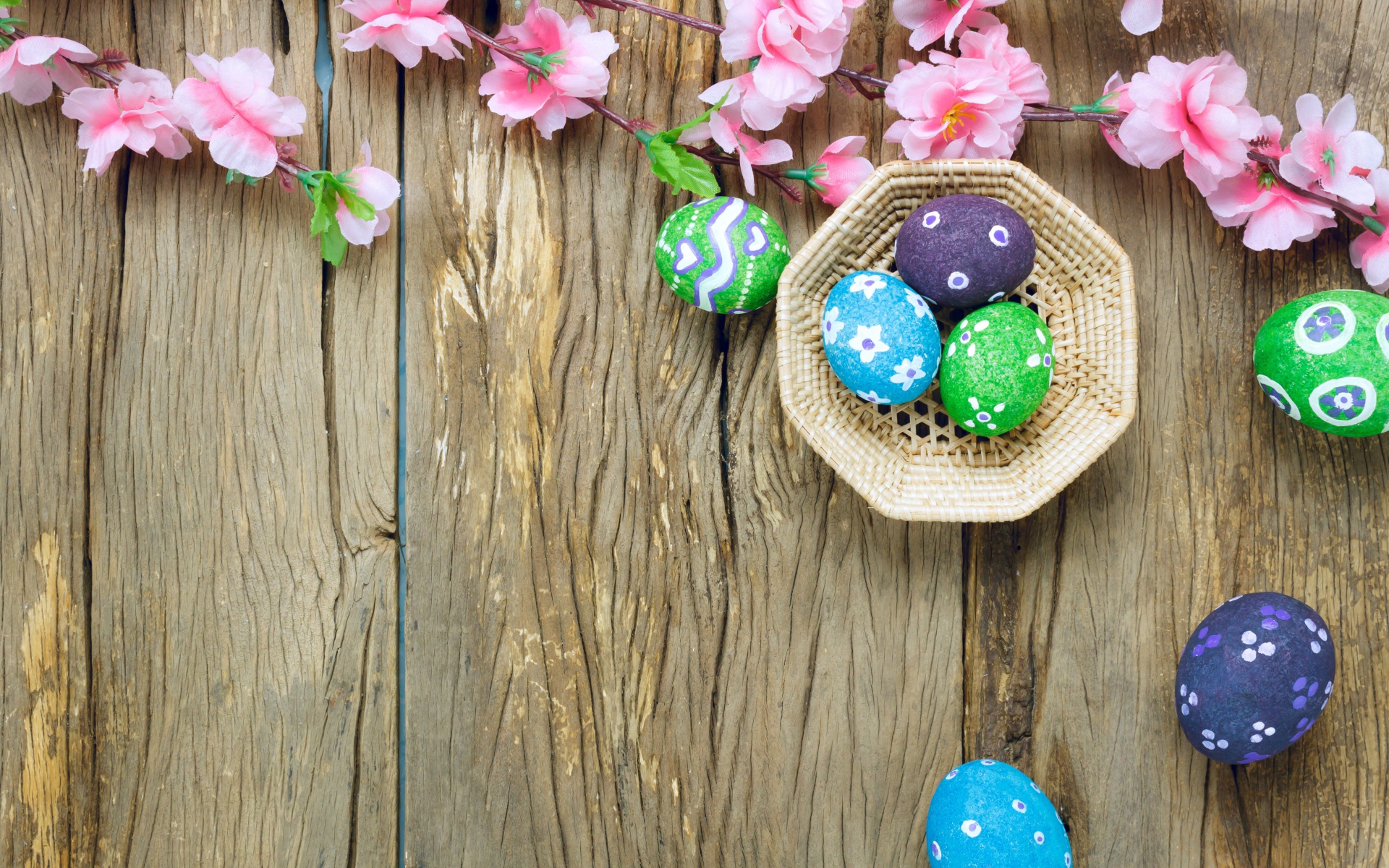 Яркие разноцветные яйца с розовыми цветами на Пасху