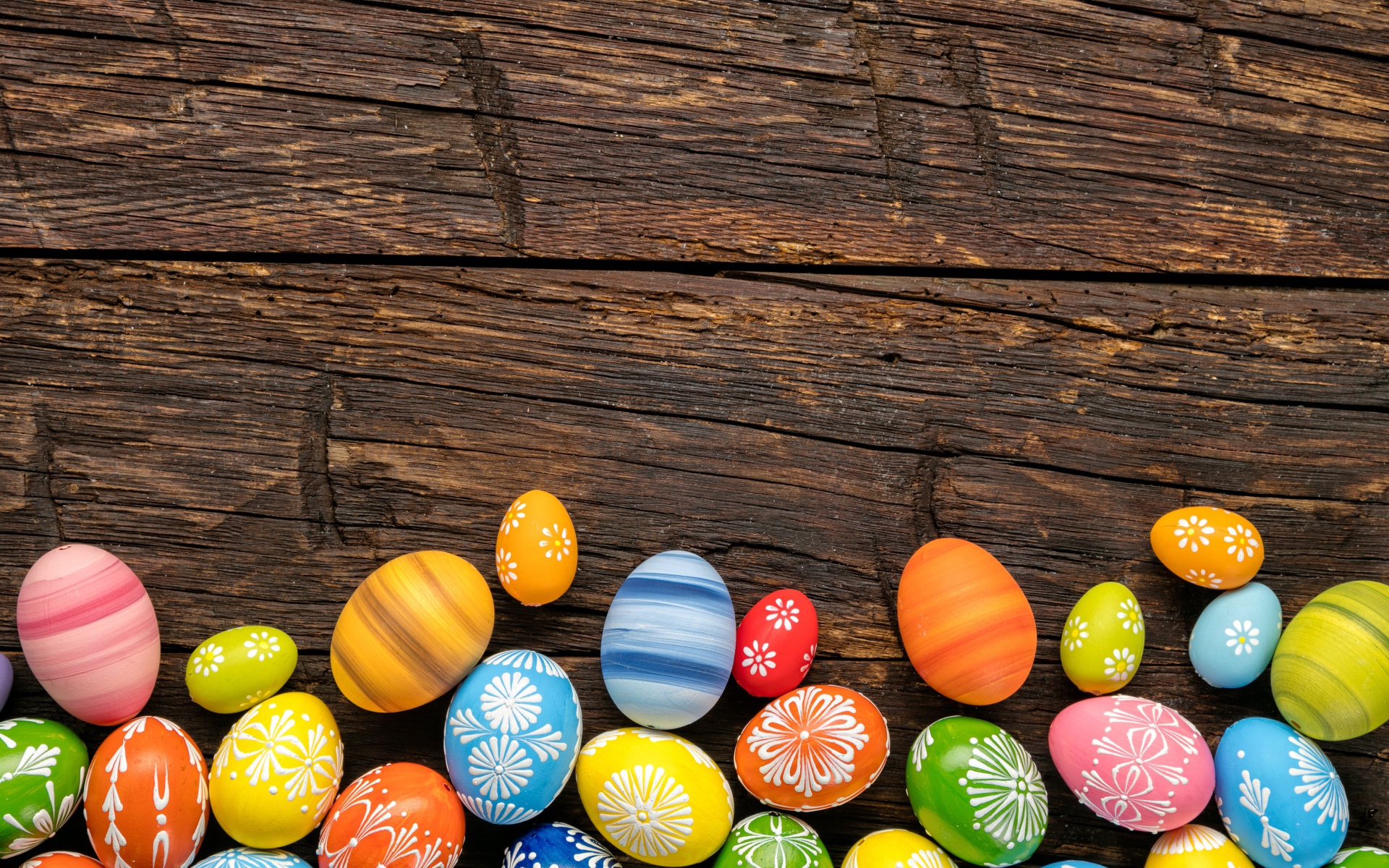 Разноцветные пасхальные яйца на деревянном столе