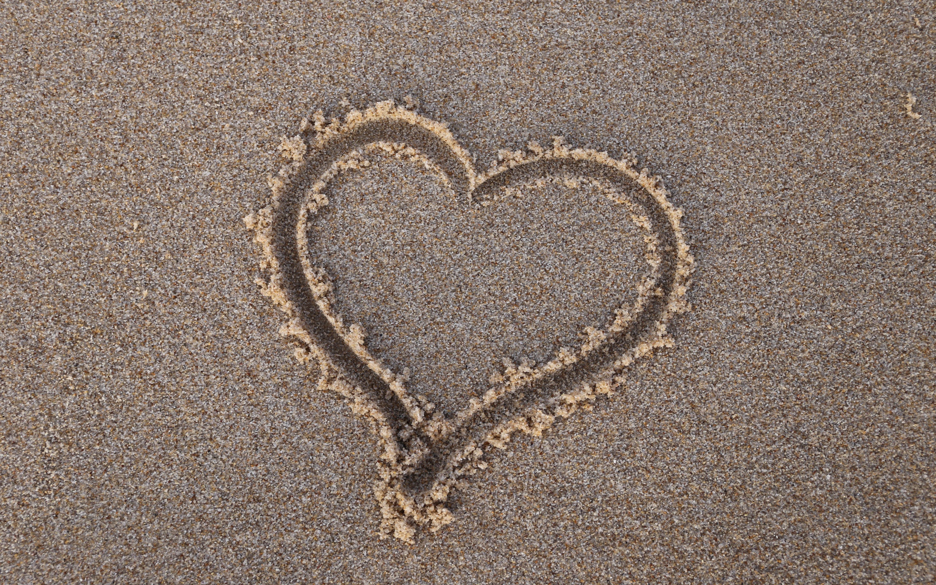 Сердце нарисовано на мокром песке 