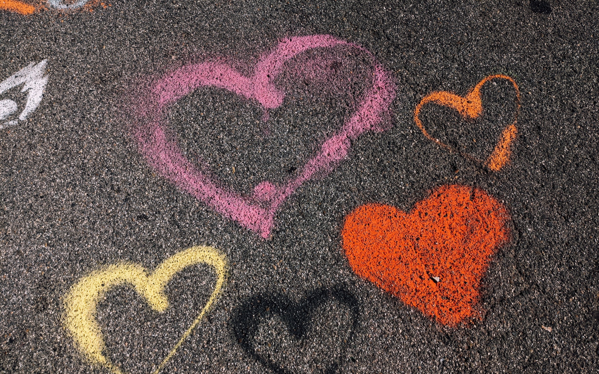 Сердечки разноцветным мелом на асфальте