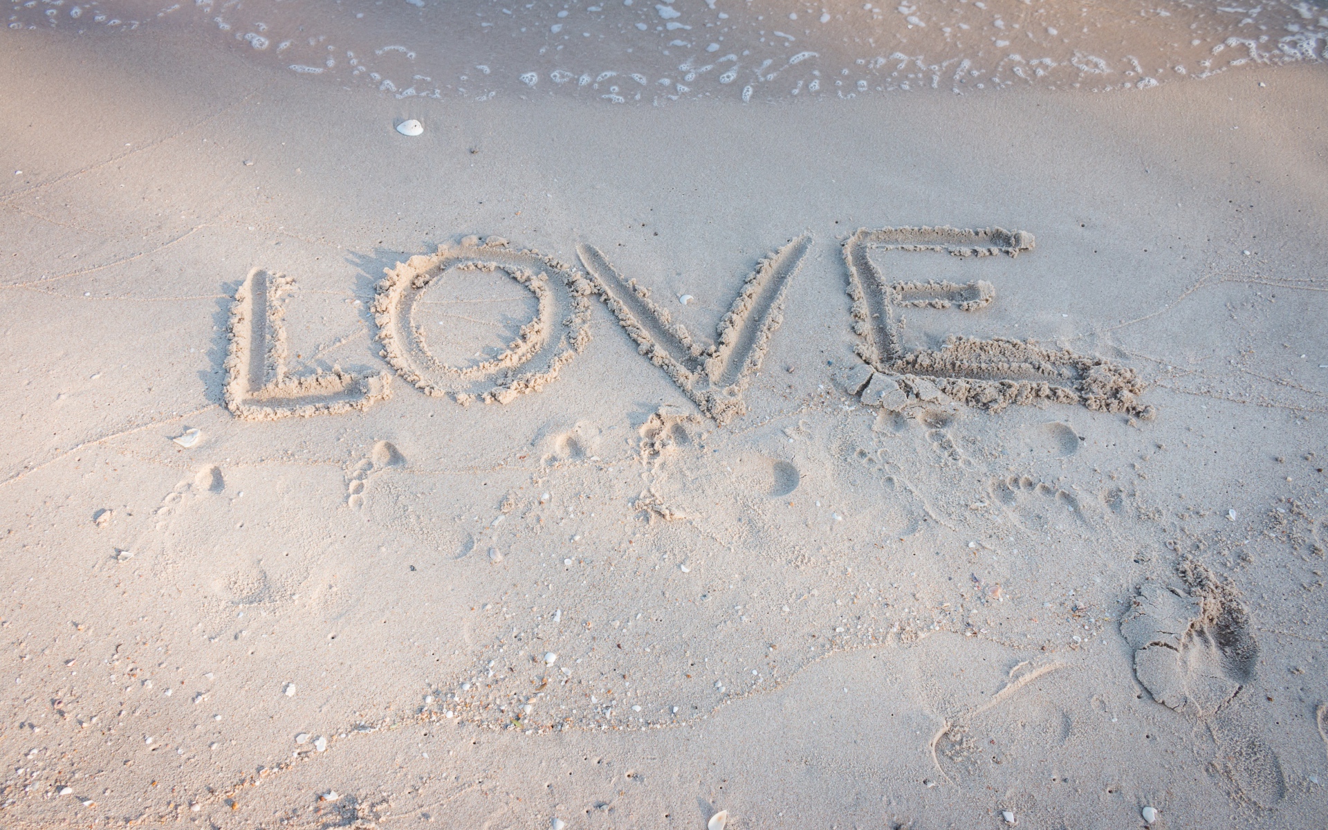 Надпись Любовь на мокром песке у моря