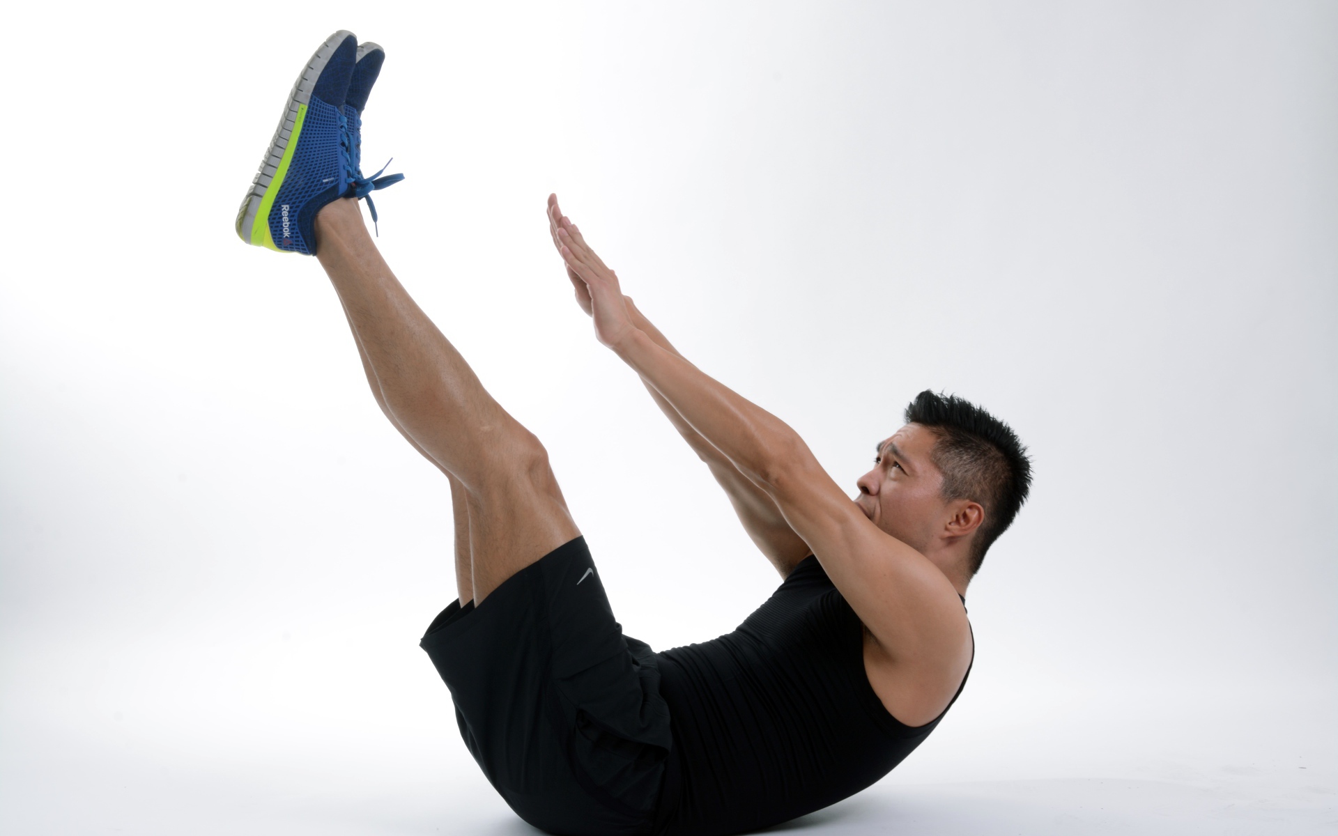 Мужчина спортсмен качает пресс на белом фоне