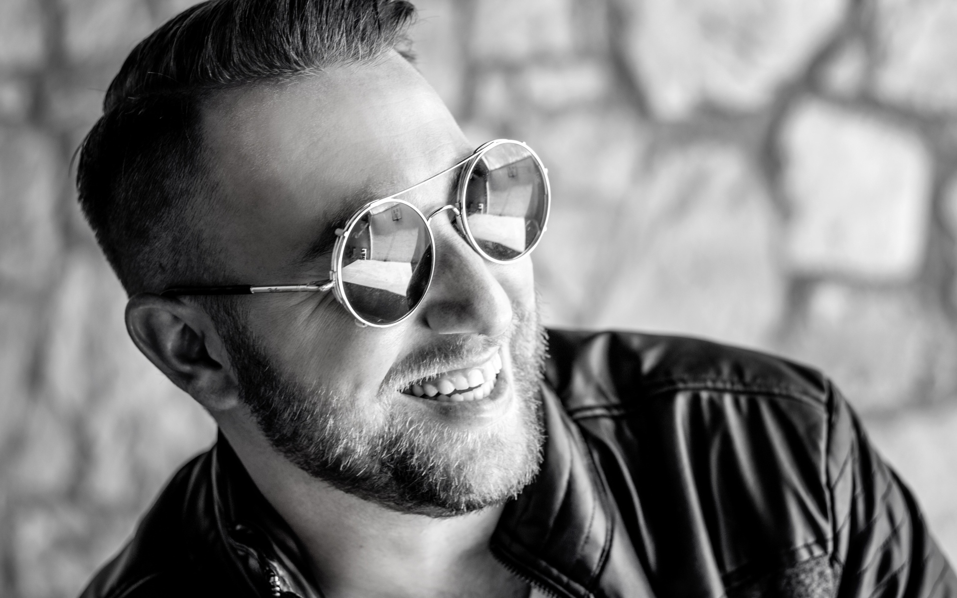 Улыбающийся брутальный мужчина в черных очках