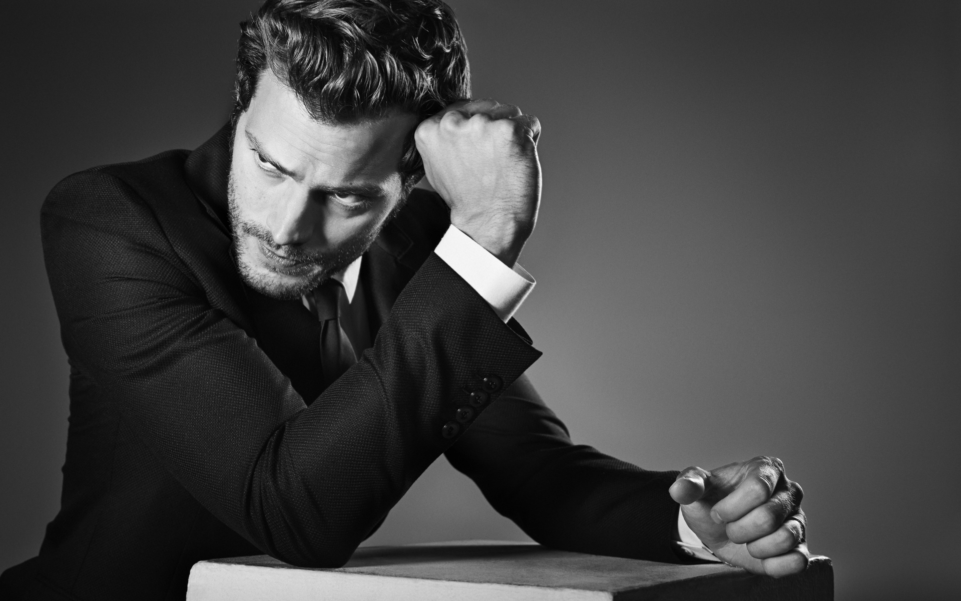 Британский актер Джейми Дорнан на сером фоне