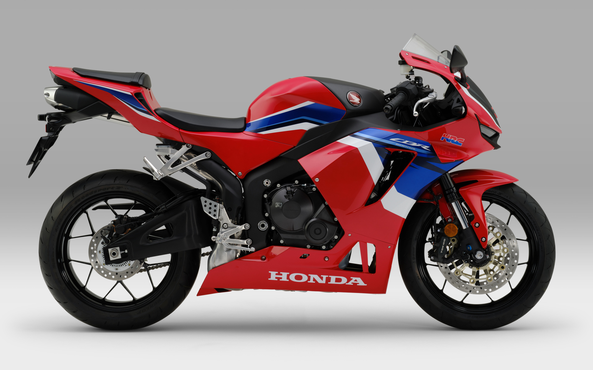 Красный мотоцикл Honda cbr600rr 2021 на сером фоне