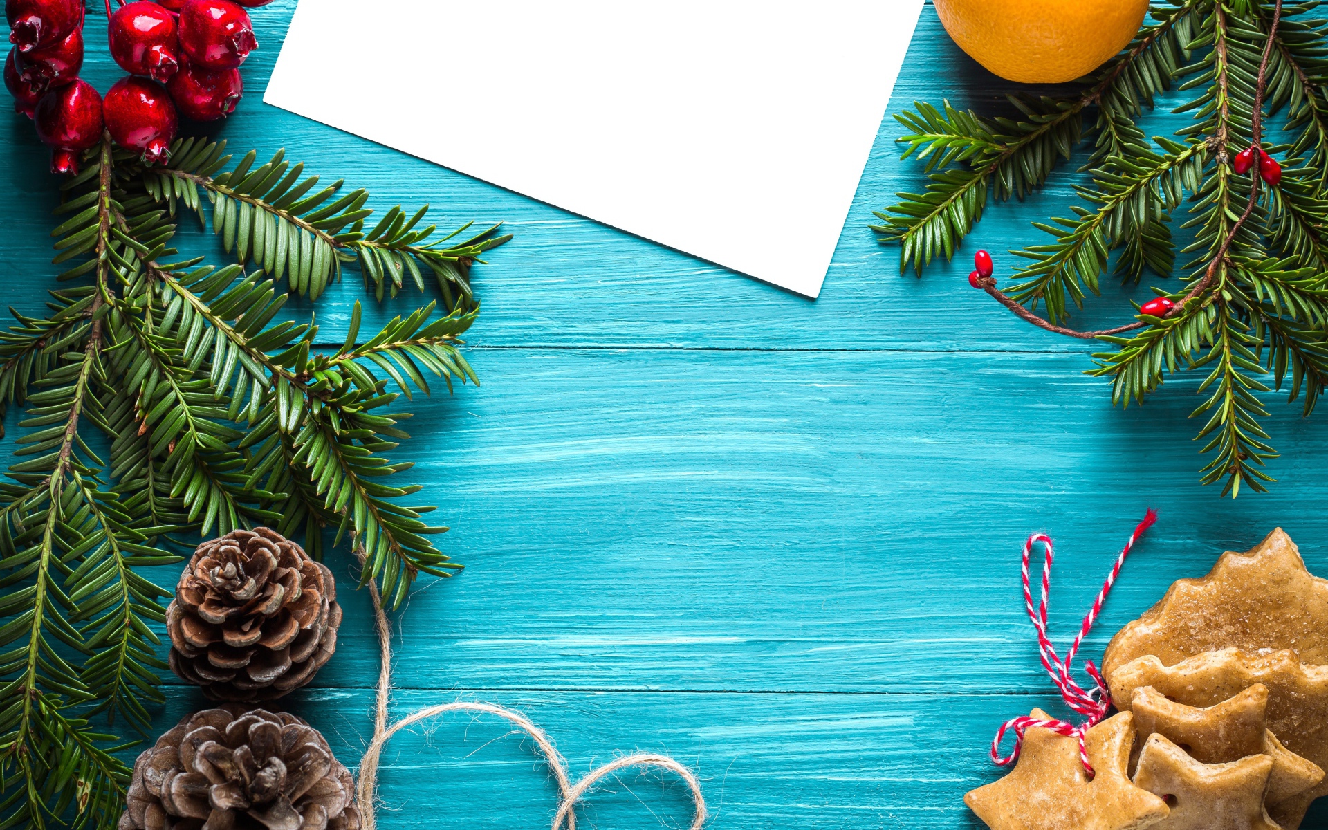 Еловые ветки с печеньем, шишками и декором на синем фоне