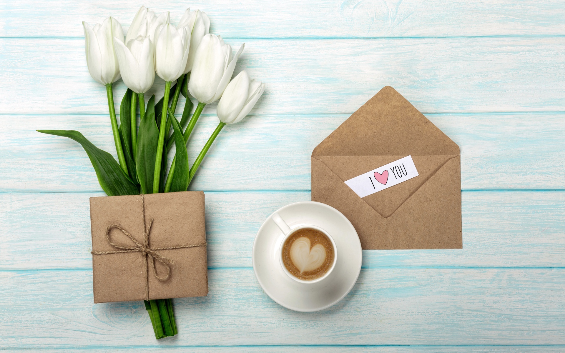 Букет белых тюльпанов на столе с подарком и чашкой кофе