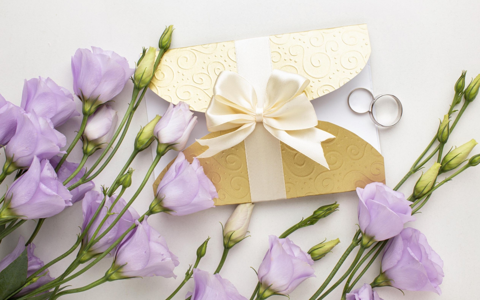 Фиолетовые цветы эустома с приглашением и обручальными кольцами