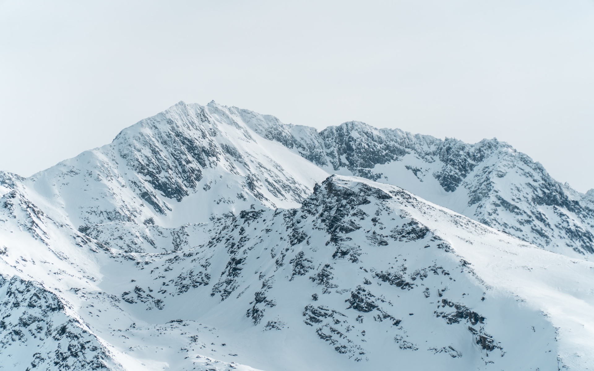 Заснеженная гора под серым небом 