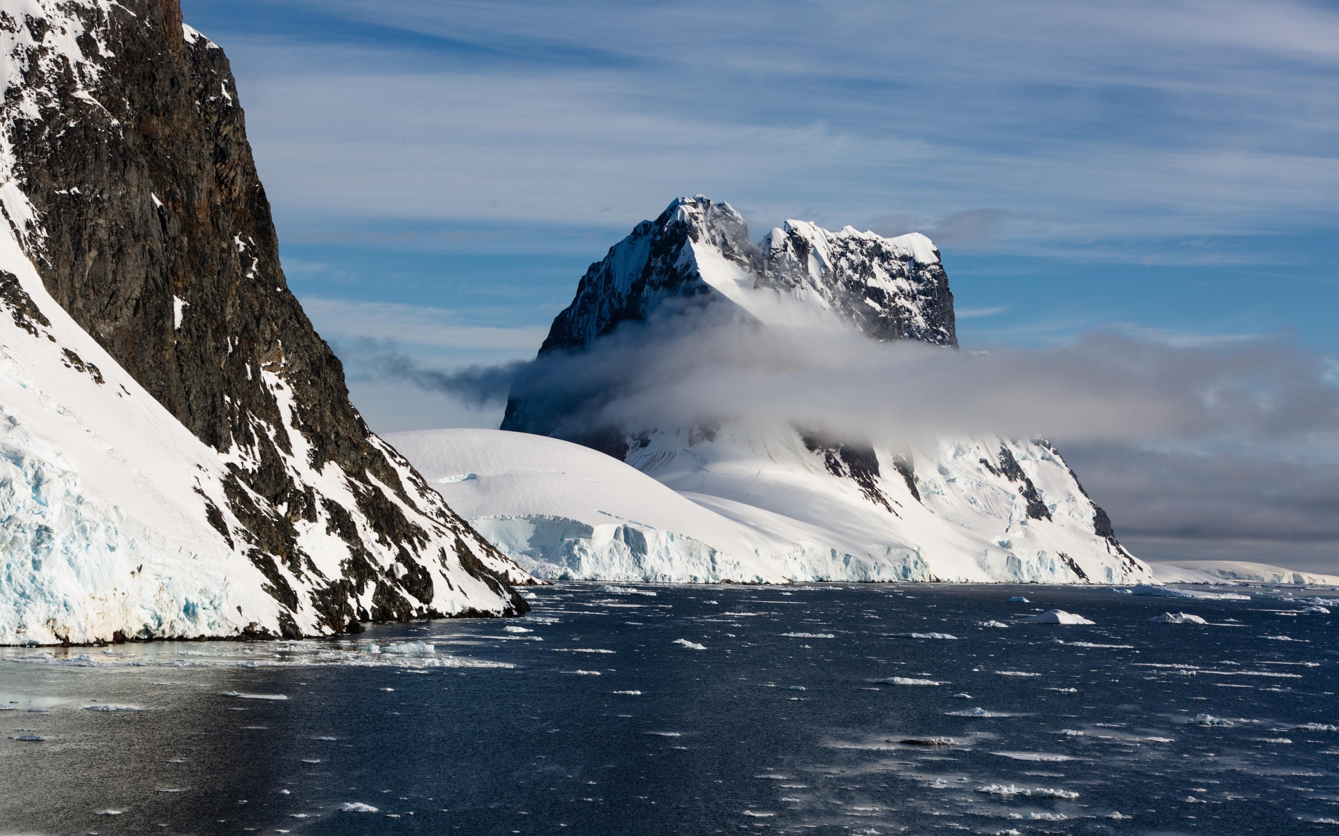 Заснеженные горы у покрытого льдом океана 