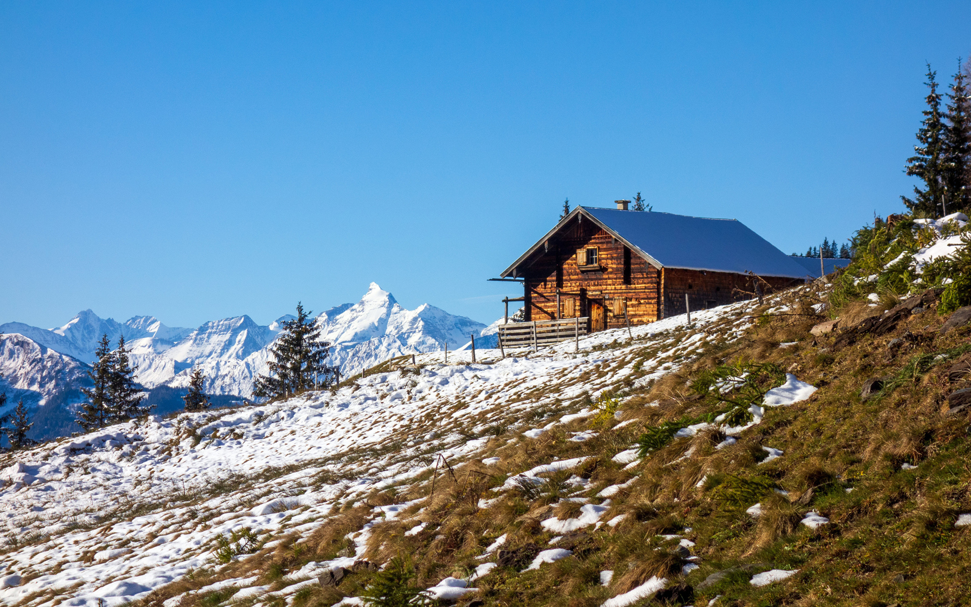 Деревянный дом на заснеженном склоне Альп
