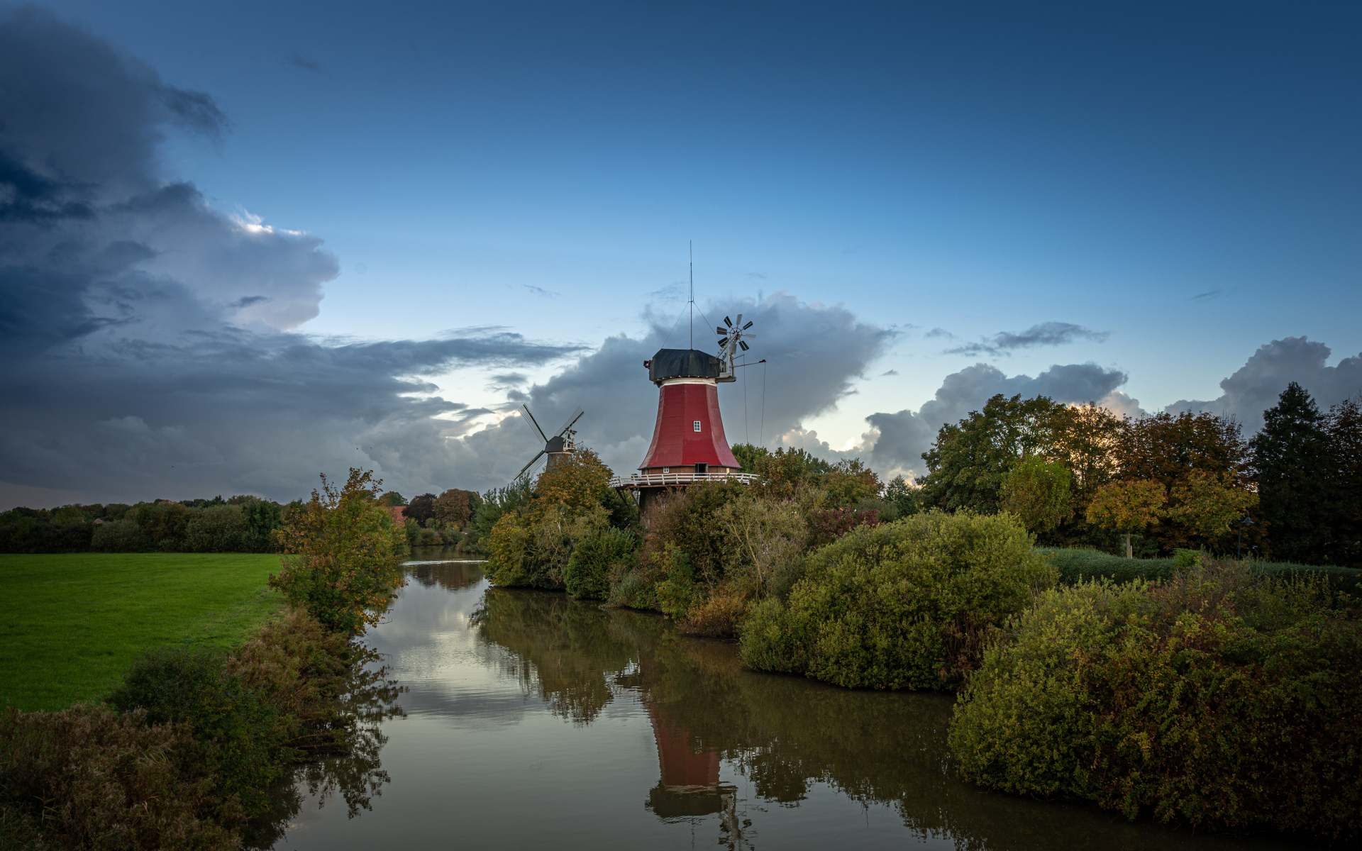 Мельница на берегу реки под красивым небом в сумерках