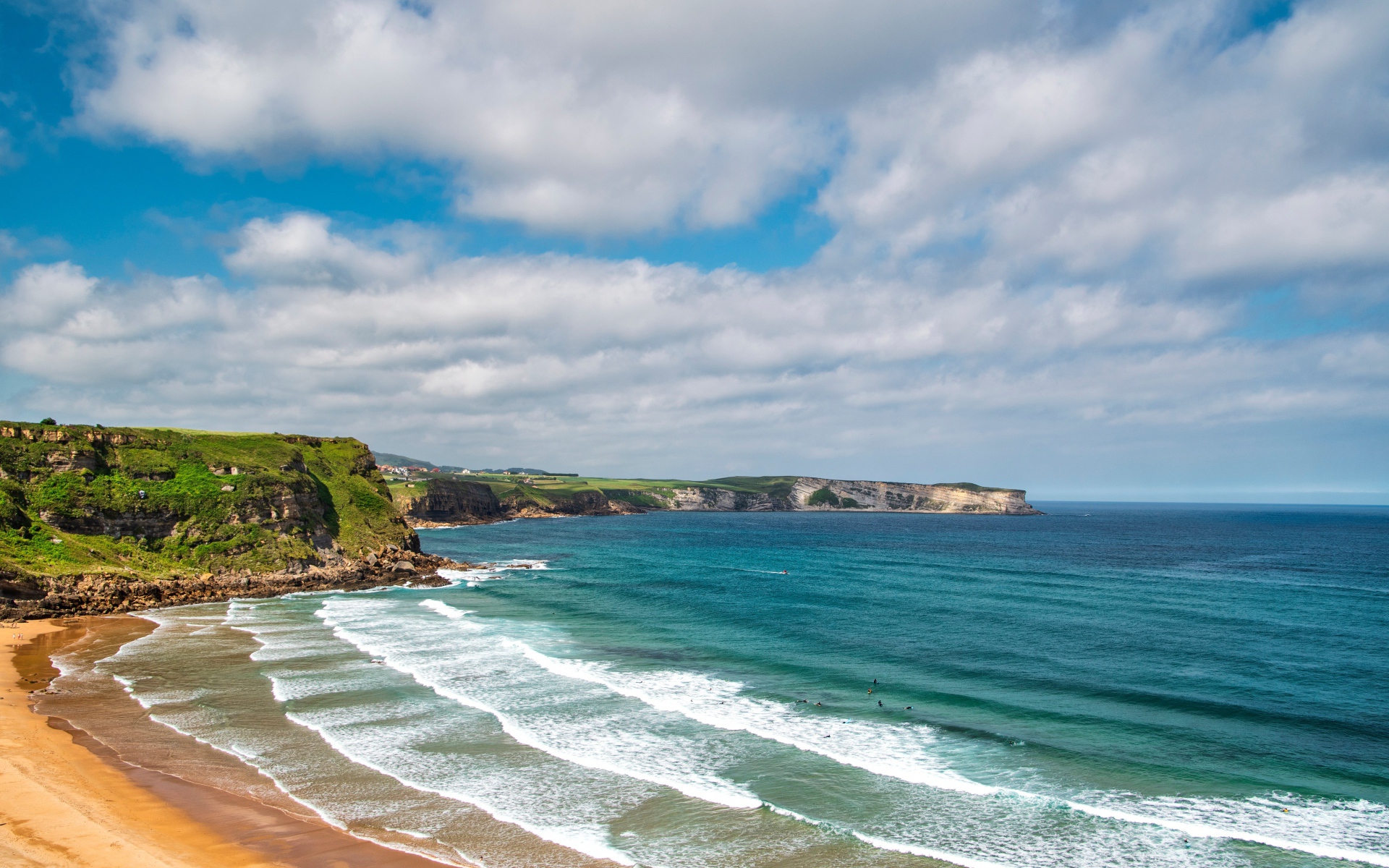 Спокойные волны на берегу залива под голубым небом с облаками