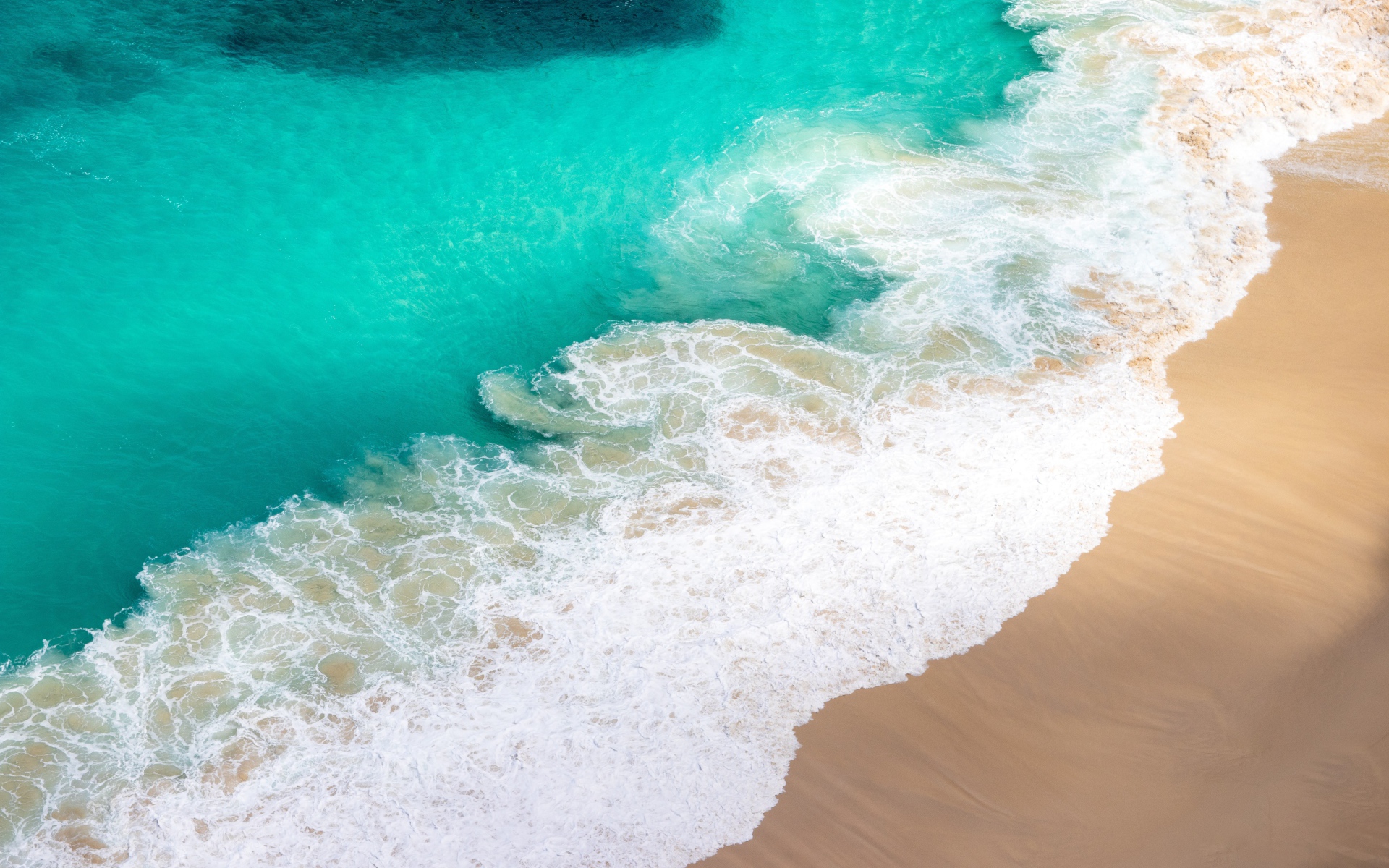 Вид сверху на белые волны прибоя 