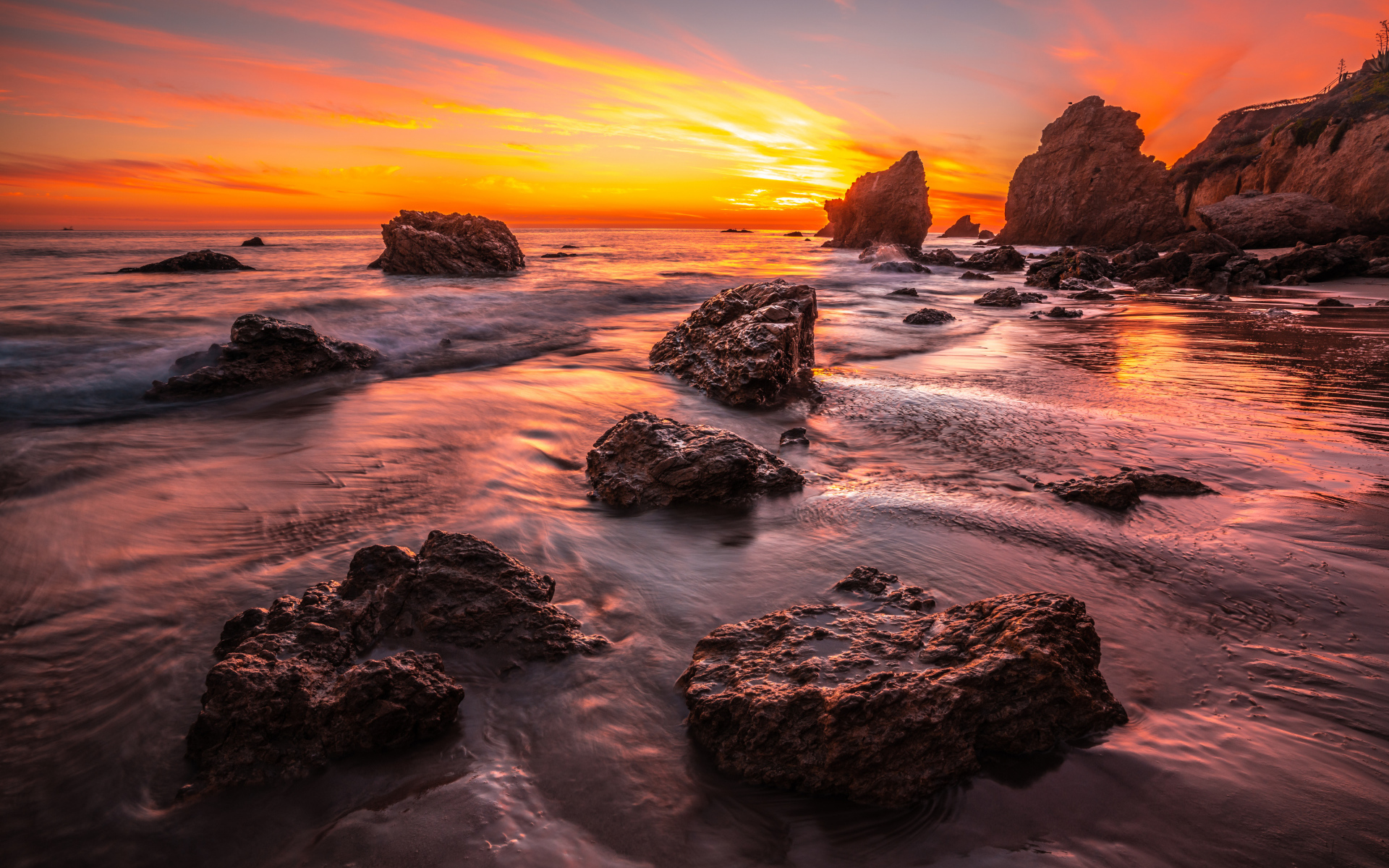 Красивый закат солнца на берегу моря с камнями 