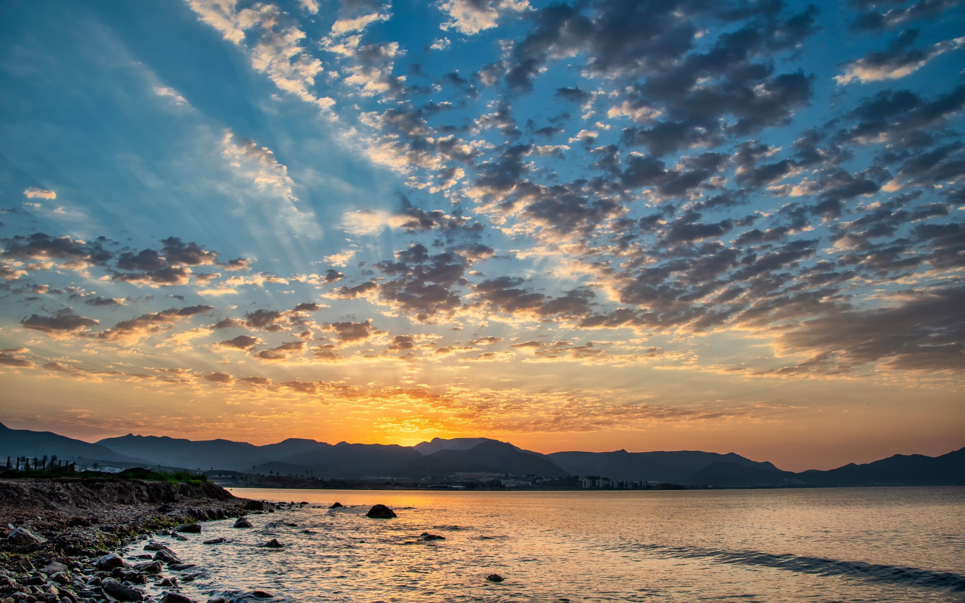 Рассвет солнца за горой у озера 