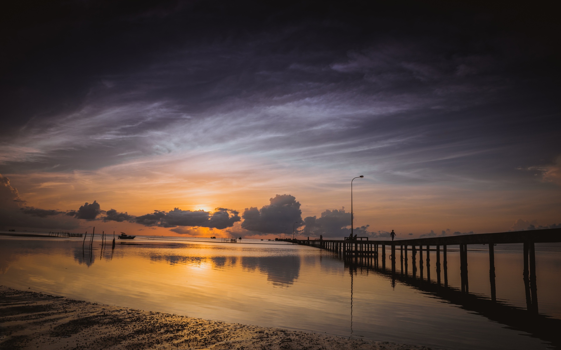 Деревянный мост на реке в лучах  солнца на закате