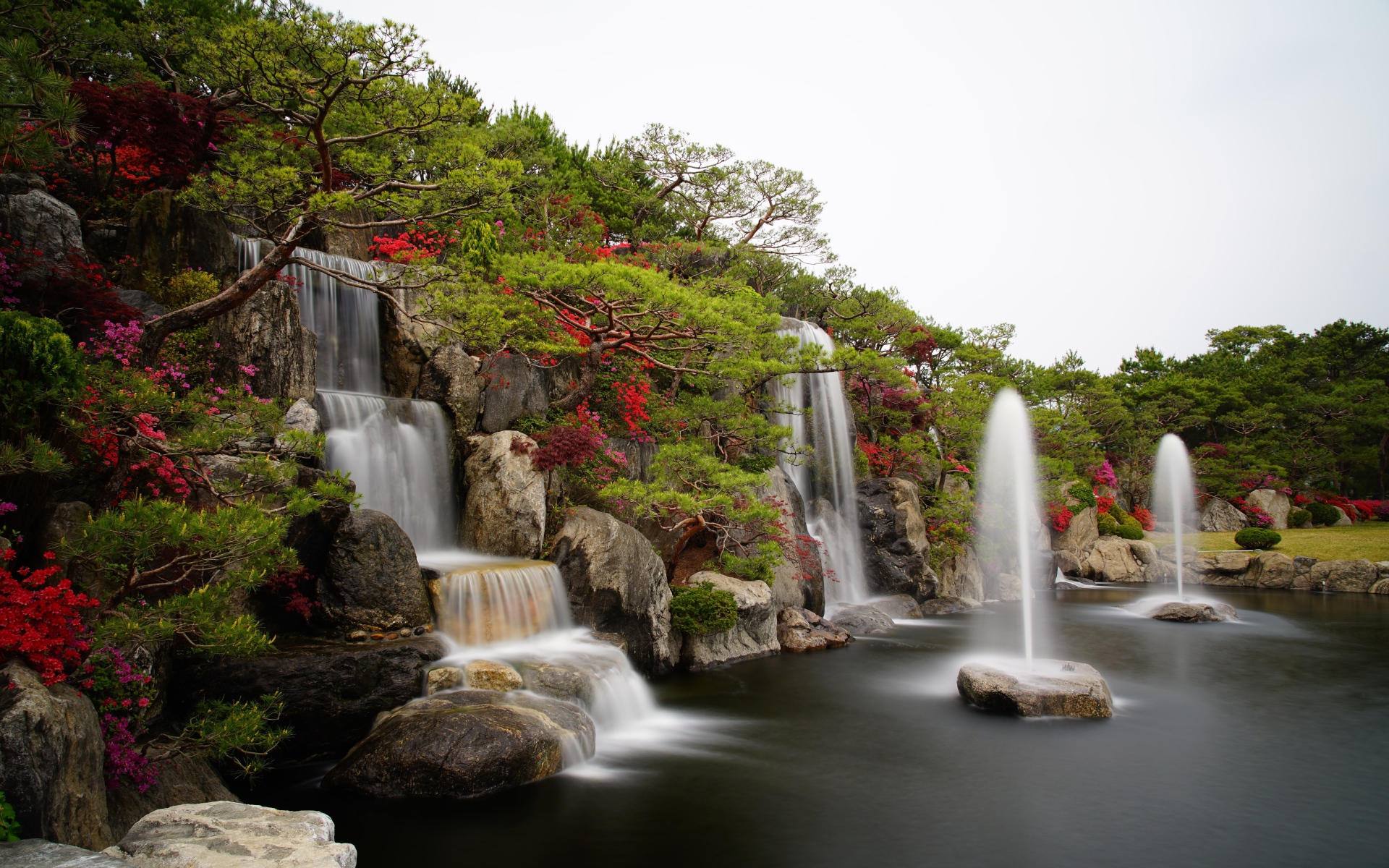 Водопады в красивом саду с зелеными деревьями