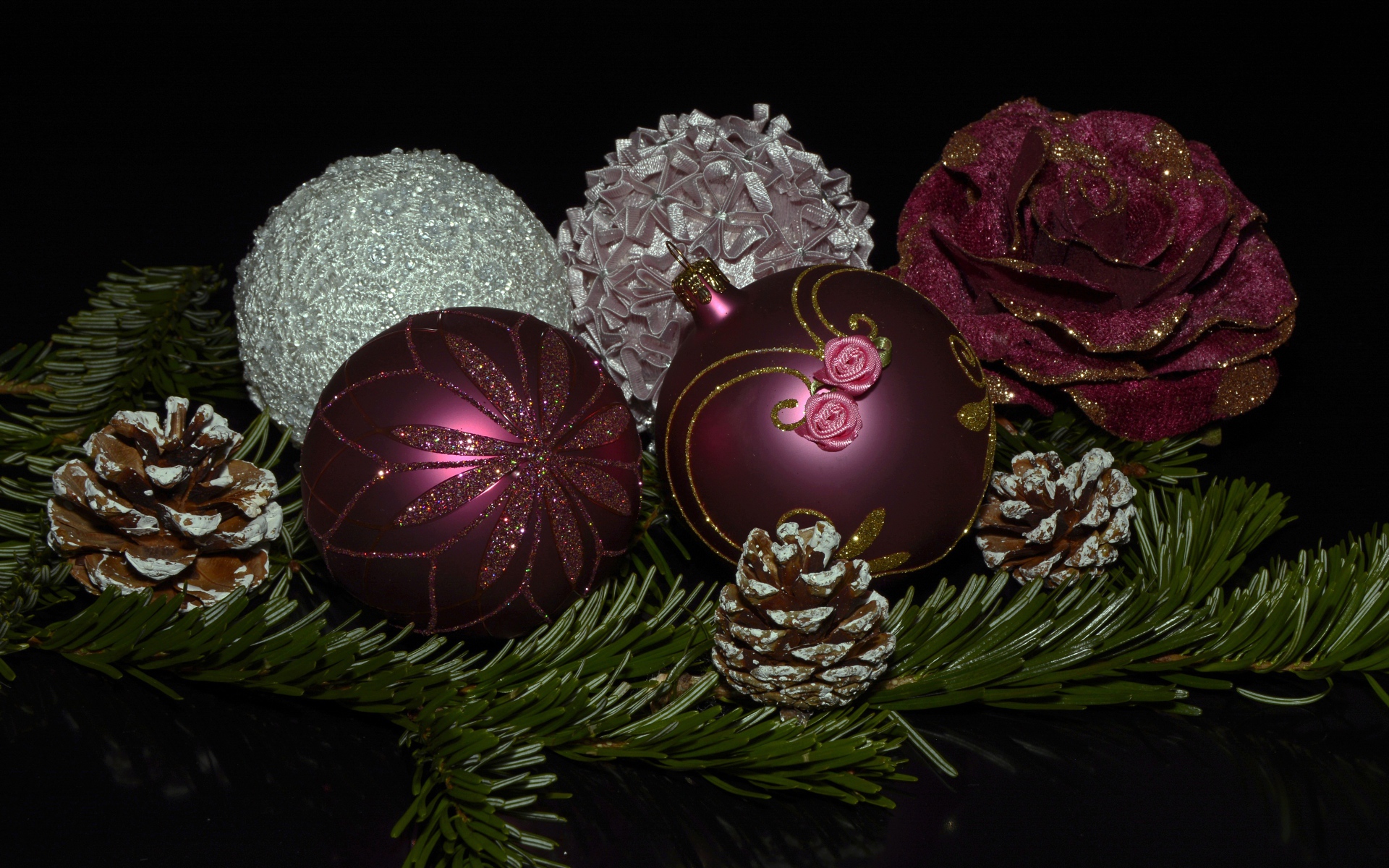 Красивые елочные игрушки с веткой на черном фоне 