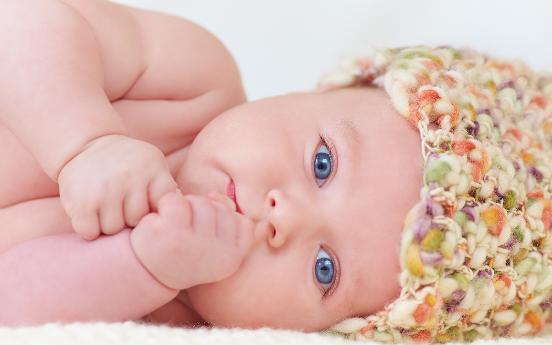 Голубоглазый грудной ребенок в шапке 