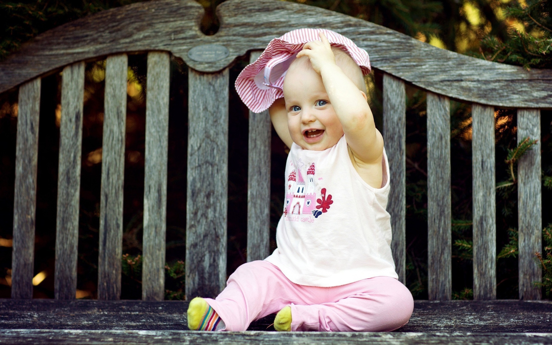 Смешной маленький ребенок сидит на лавке