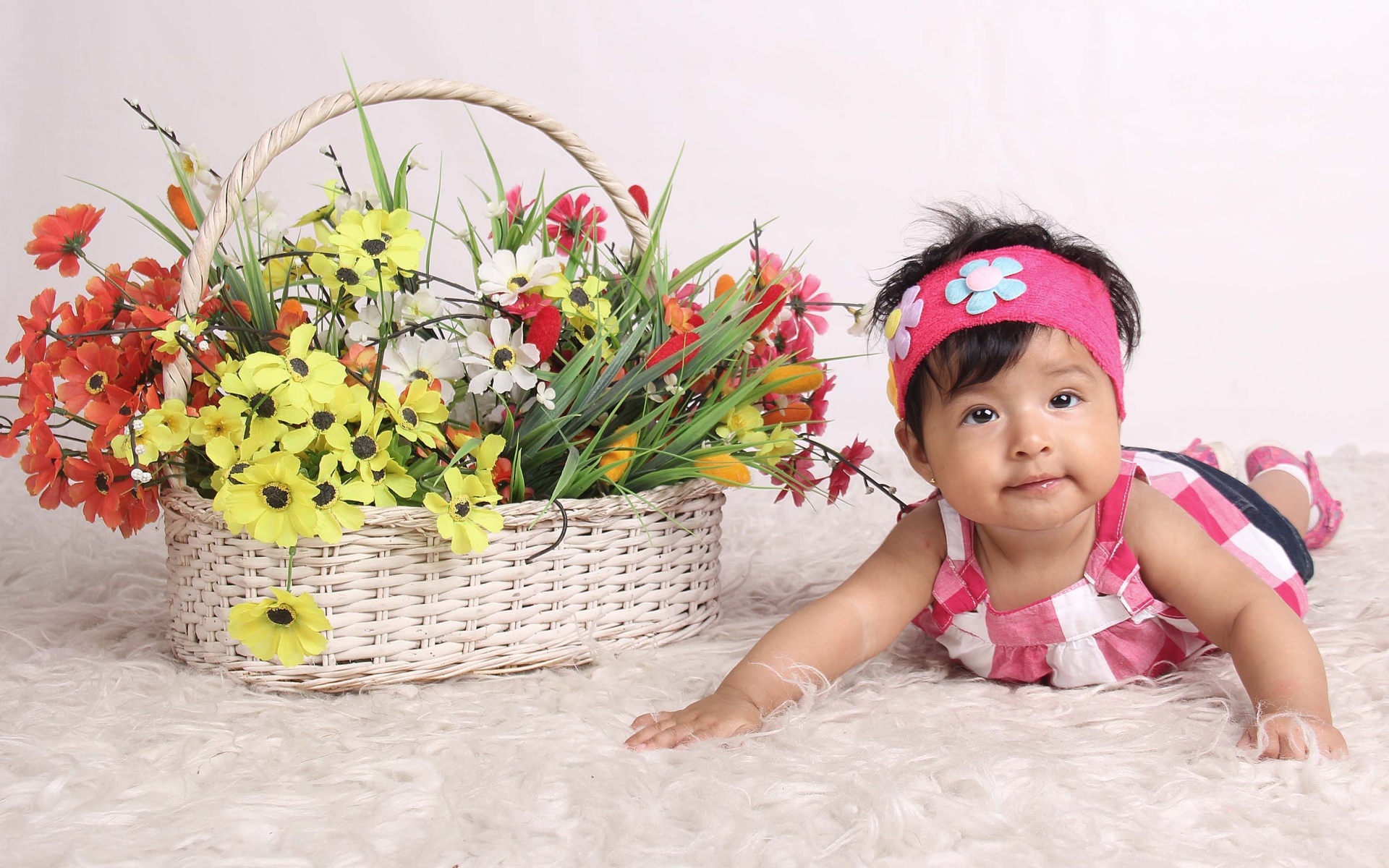 Маленькая девочка рядом с корзиной цветов 