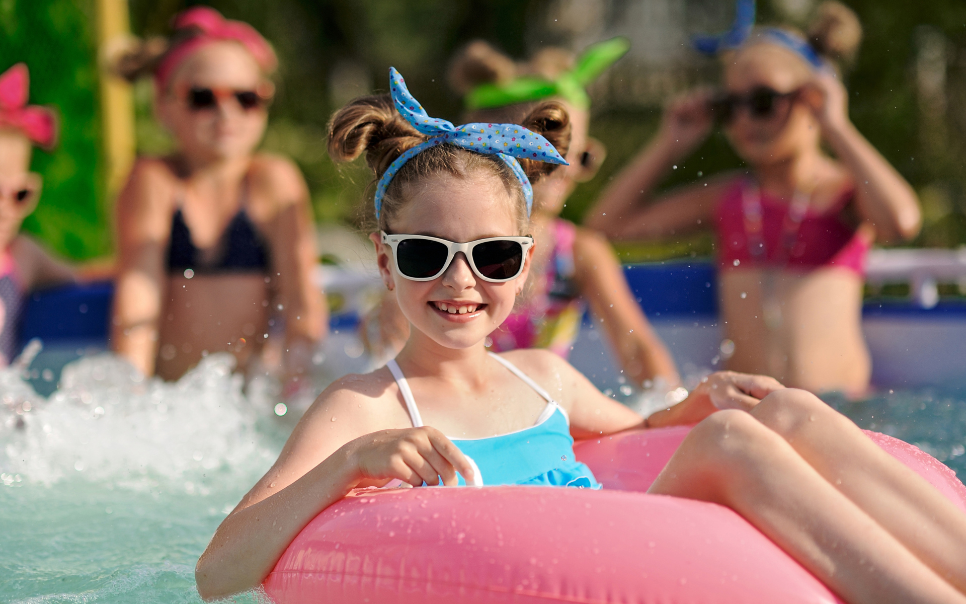 Улыбающаяся девочка со спасательным кругом в бассейне 