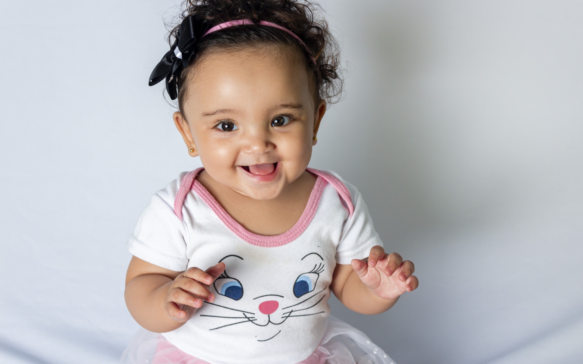 Улыбающаяся маленькая девочка на сером фоне 