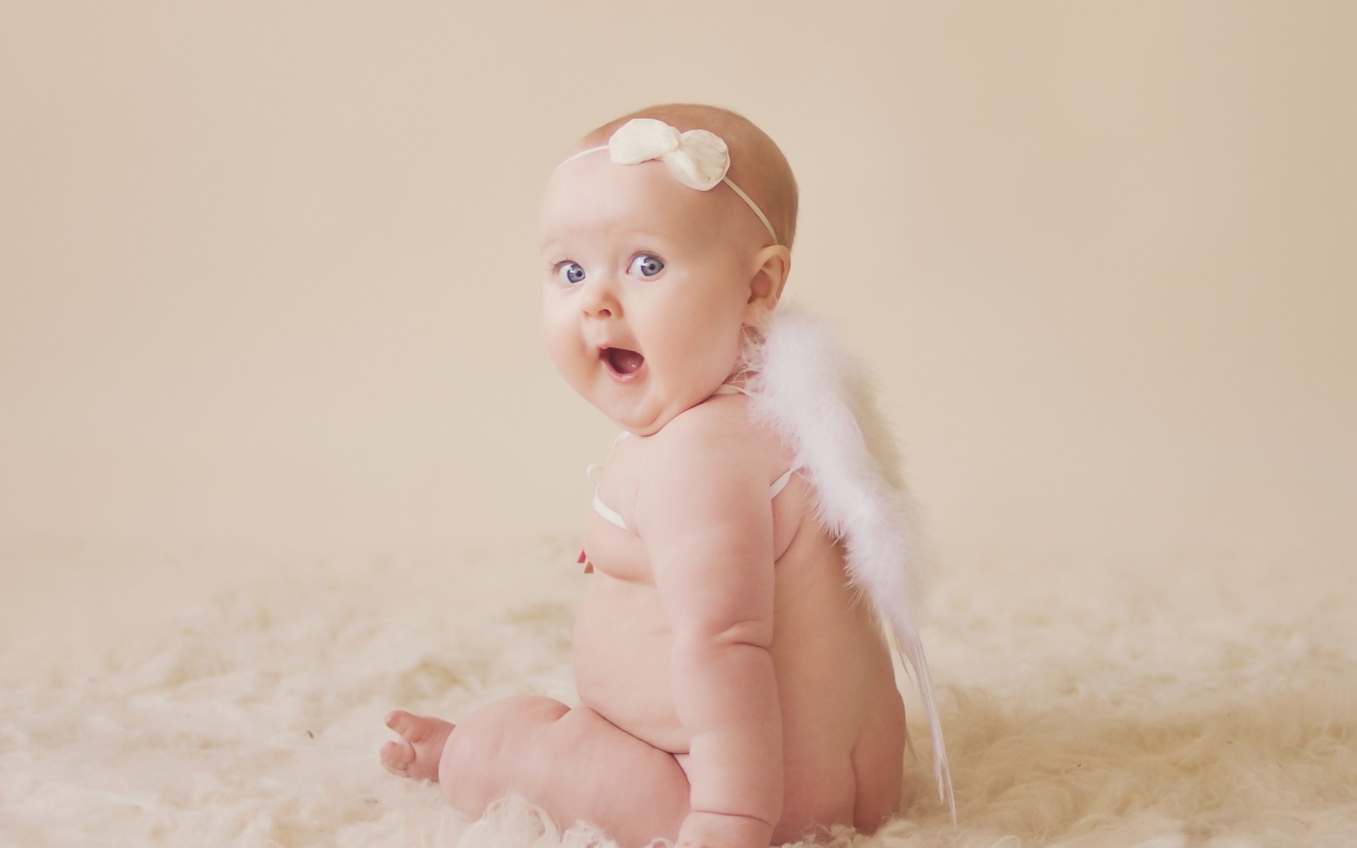 Удивленный грудной ребенок с белыми крыльями за спиной 