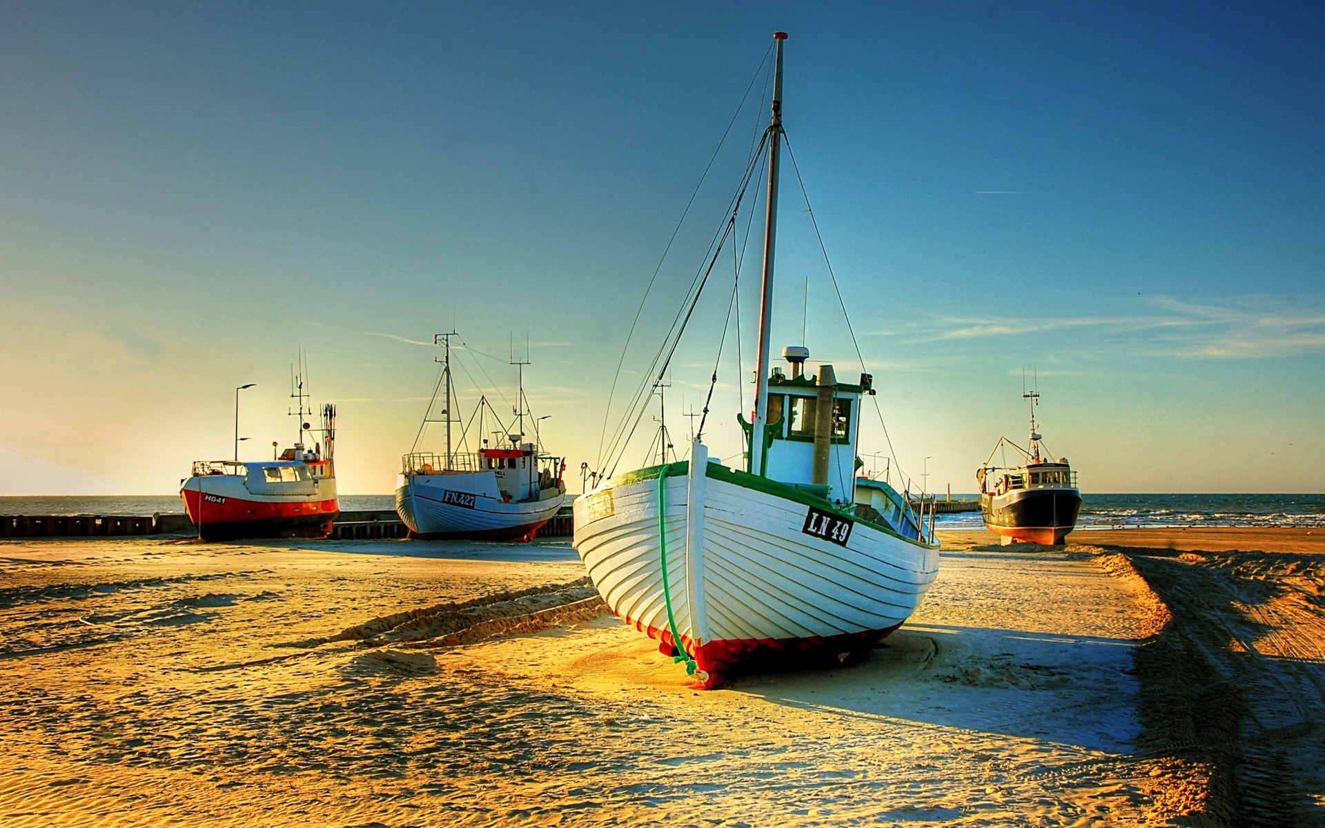 Рыболовные лодки в лучах солнца на берегу 